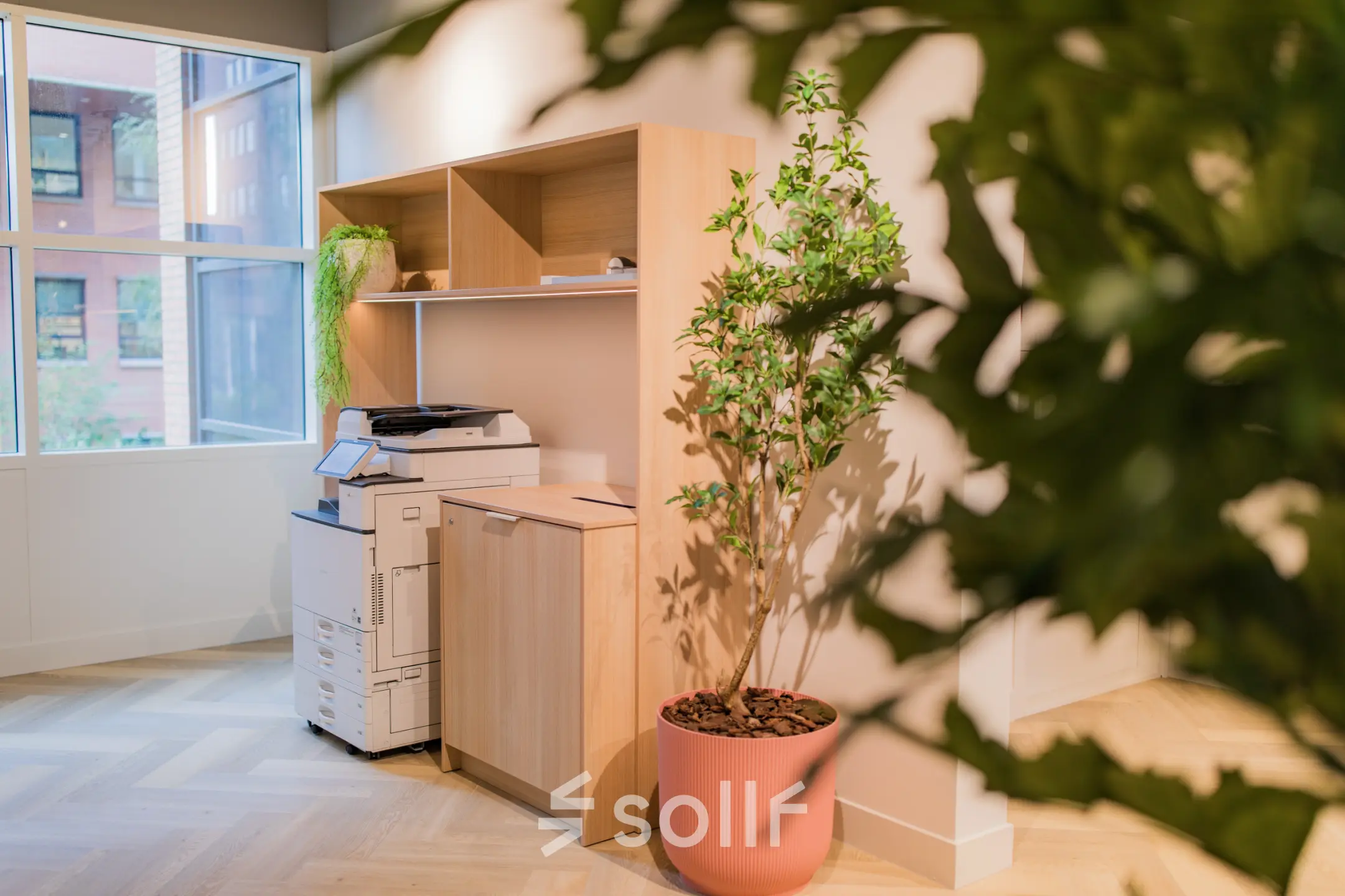 Licht kantoorinterieur met printer, houten kast en groene plant op Hullenbergweg 109-135 in Amsterdam Zuid-Oost; ideaal voor kantoorruimte huren.