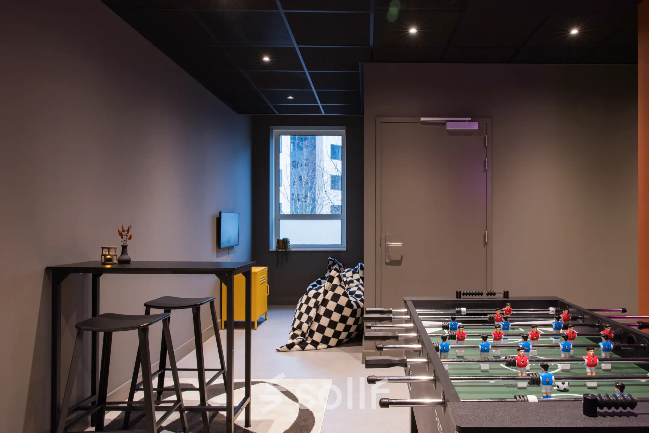 Speelse kantoorruimte te huur op Hullenbergweg 109-135 in Amsterdam Zuid-Oost, met een tafelvoetbaltafel en zitgedeelte. Ideaal voor ontspannen pauzes tussen het werken door.