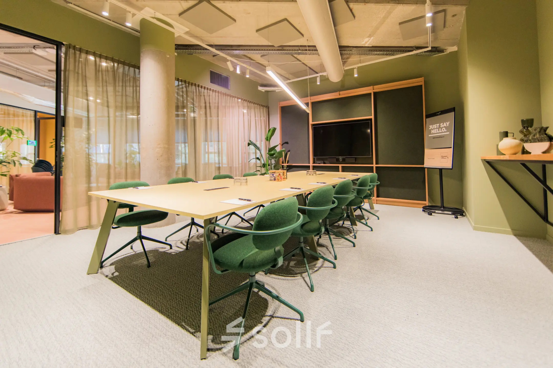 Moderne vergaderruimte in een kantoorpand aan de Hullenbergweg 109-135, Amsterdam Zuid-Oost, met een grote tafel en groene stoelen, ideaal voor kantoorruimte huren.