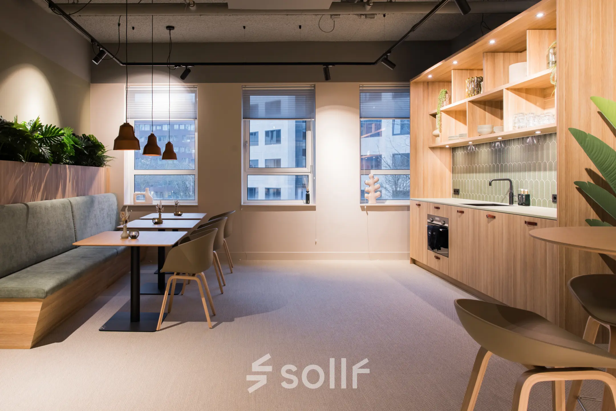Moderne kantoorruimte huren in Amsterdam Zuid-Oost met strakke keuken, houten accenten en zitgelegenheid. Ideaal voor werk- en ontmoetingsmomenten in een aangename sfeer.