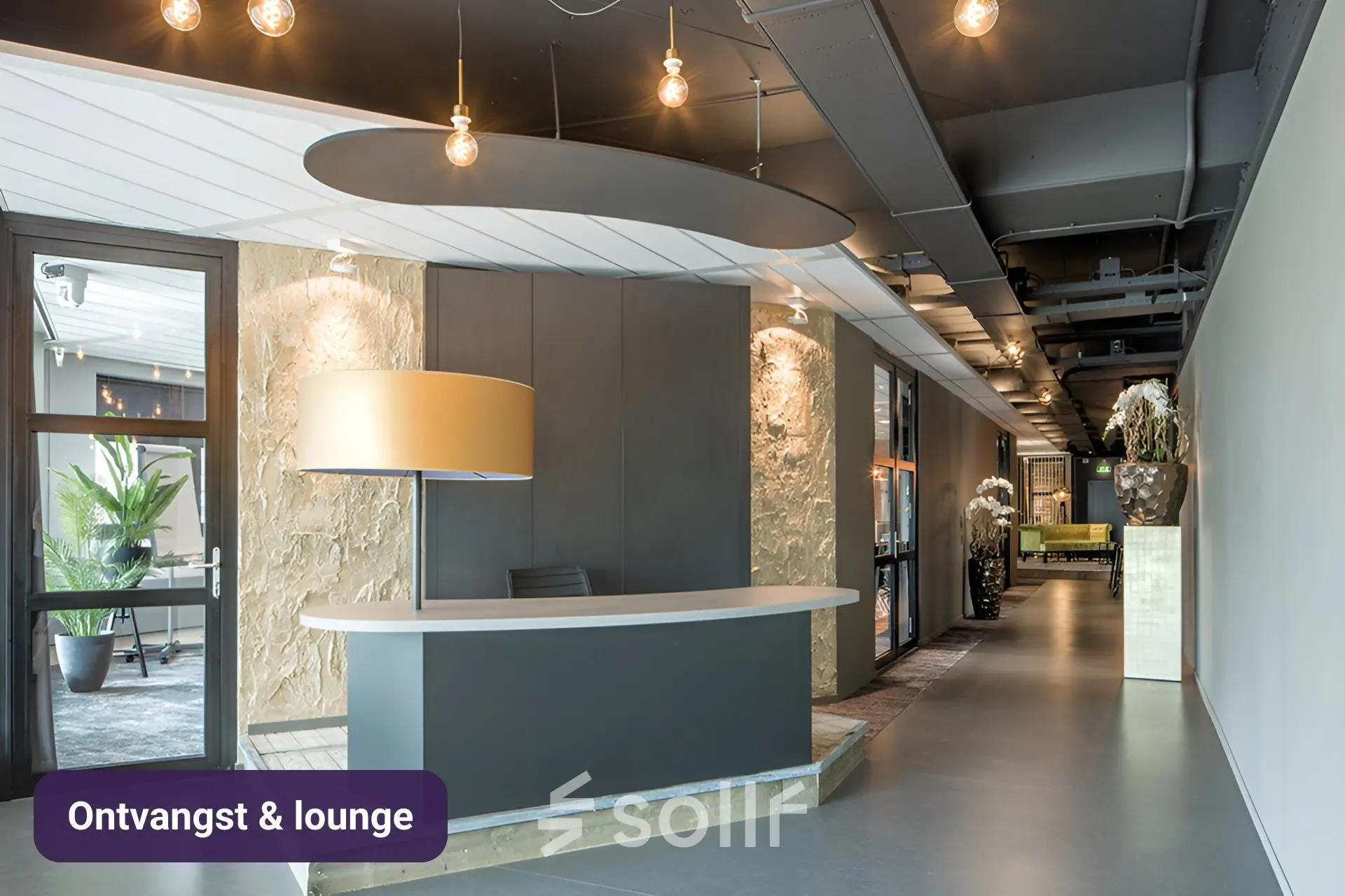 Moderne kantoorlobby met ontvangstbalie en stijlvolle verlichting op Johan Cruijff Boulevard 89, perfect voor kantoorruimte huren in Amsterdam Zuid-Oost.