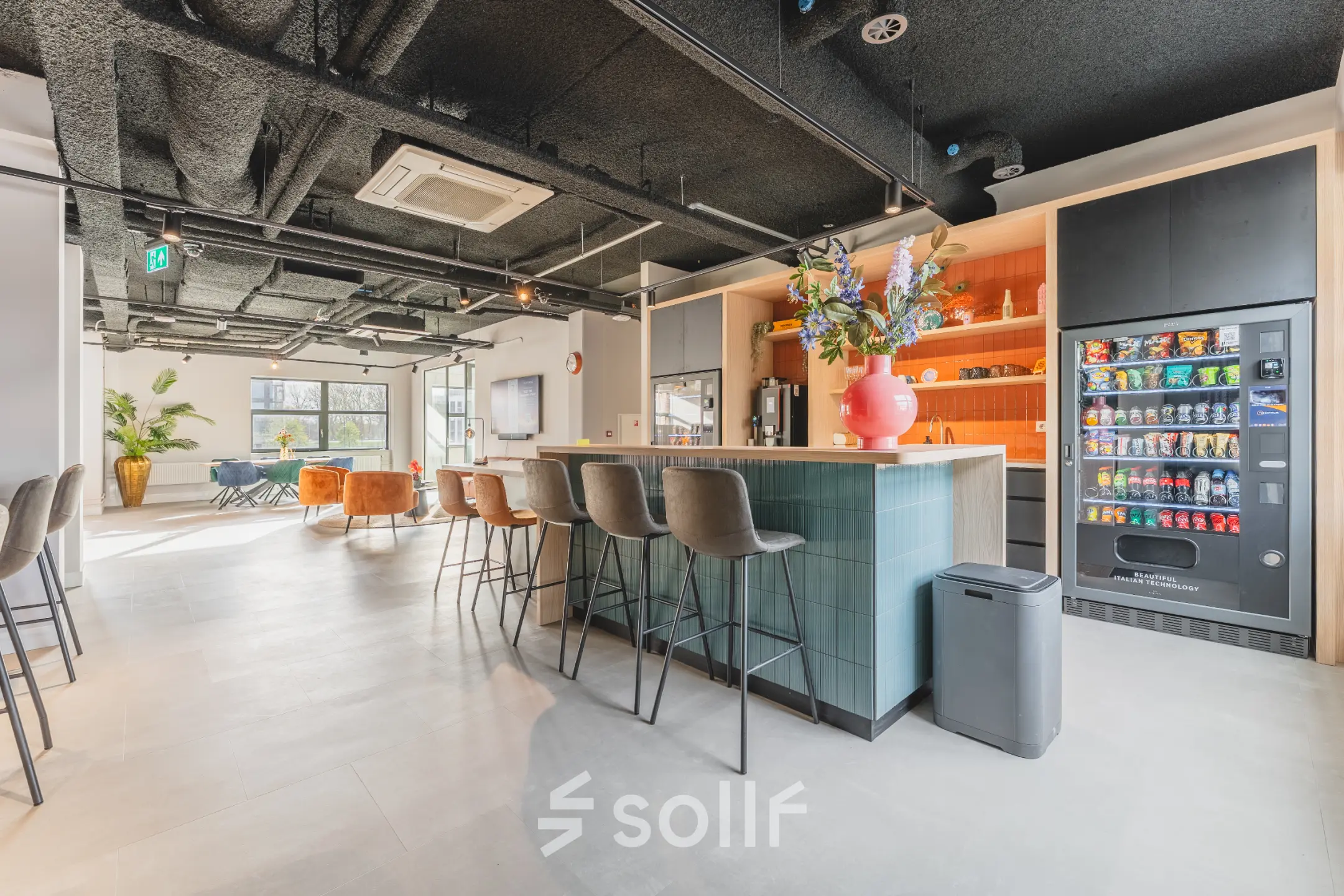 Moderne en lichte kantoorruimte op Paasheuvelweg 20 in Amsterdam Zuid-Oost met een gemeubileerde lounge en hoge stoelen aan een bar, ideaal voor informeel overleg of pauzes tijdens het huren van een kantoorpand.