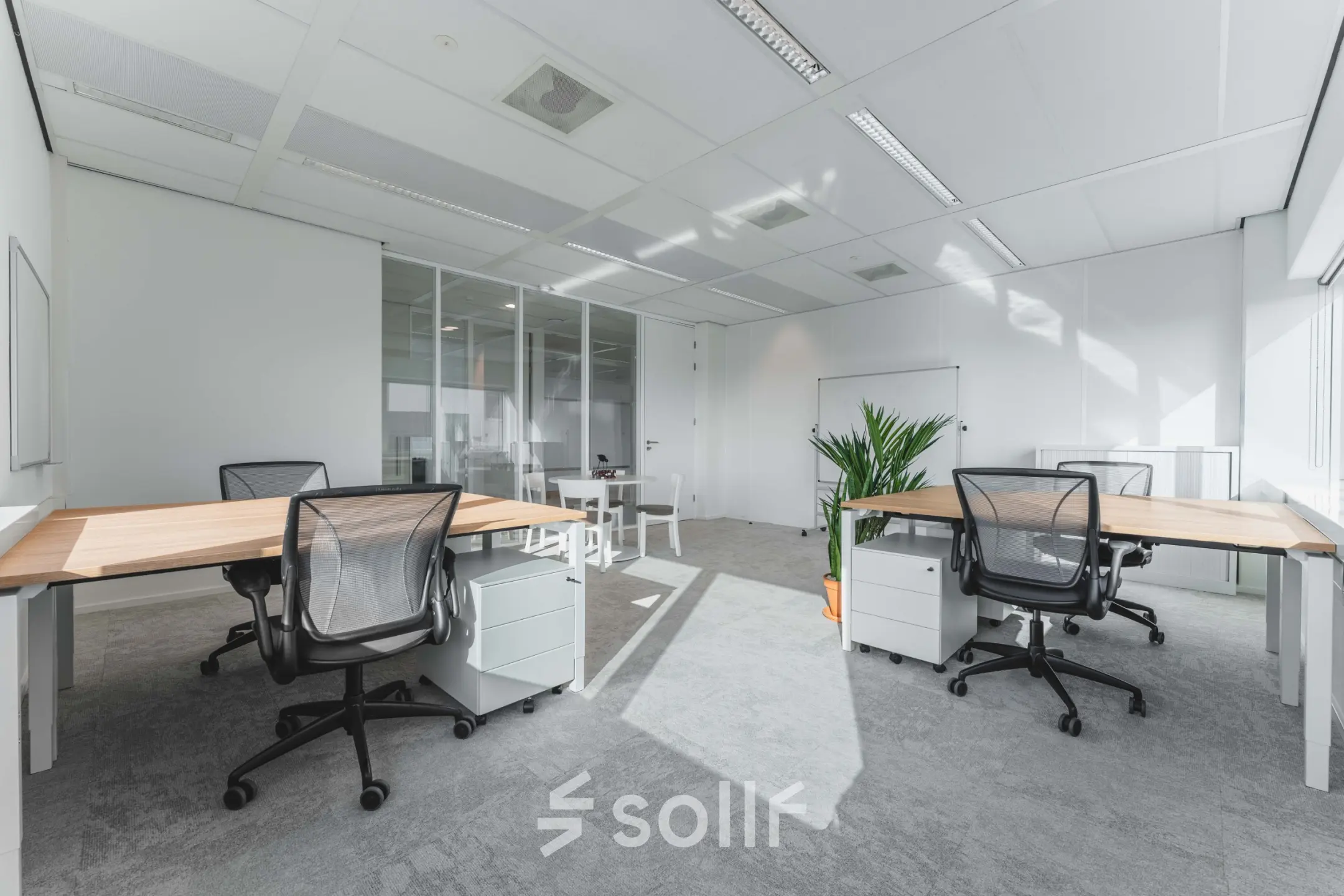 Moderne kantoorruimte te huur op Barbara Strozzilaan 101, Amsterdam Zuidas, met strakke bureaus, bureaustoelen en veel natuurlijk licht door grote ramen.