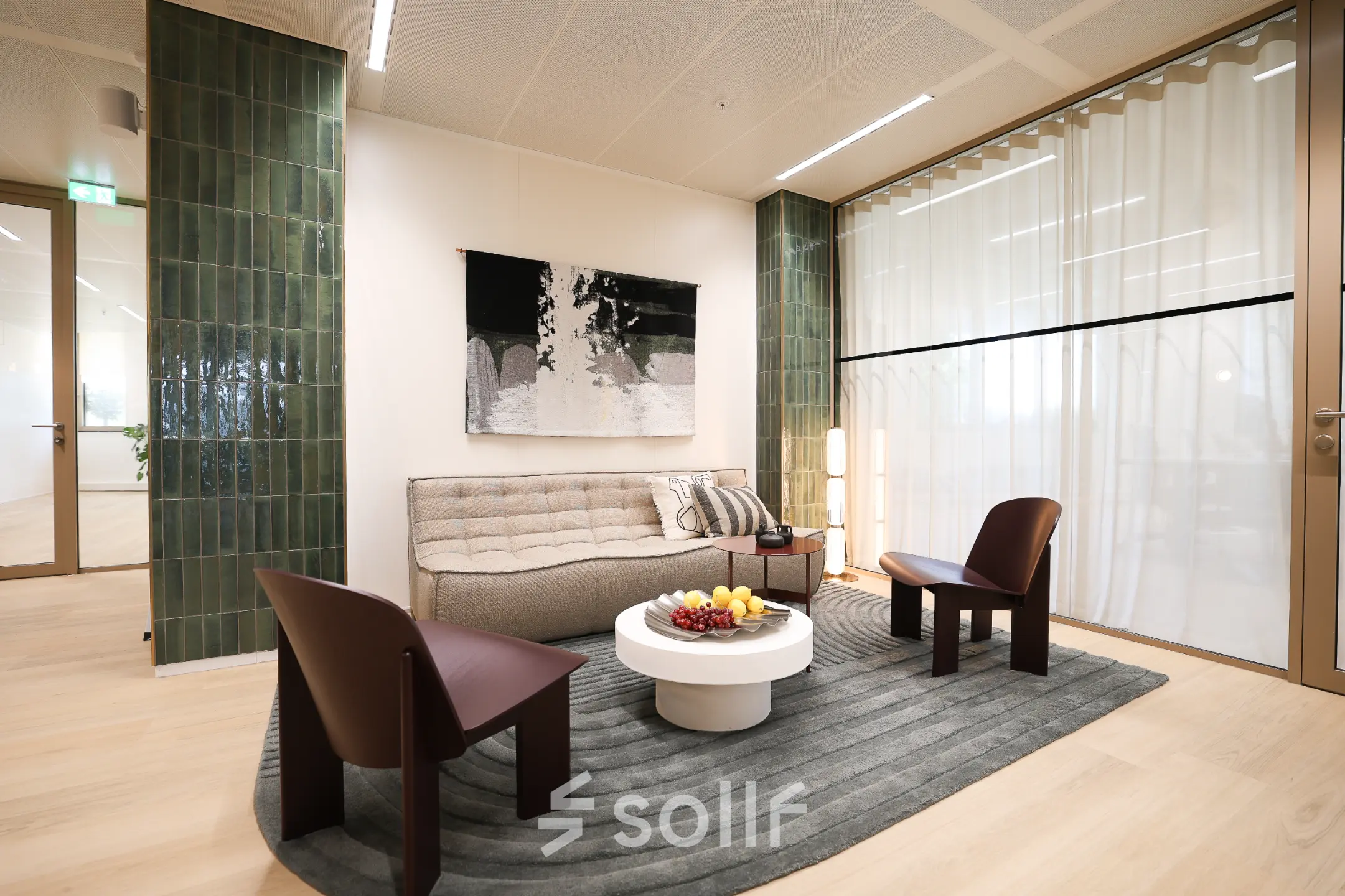 Stijlvolle kantoorruimte huren in Amsterdam Zuidas met modern interieur, comfortabele zitplekken en decoratieve kunst aan de muur.