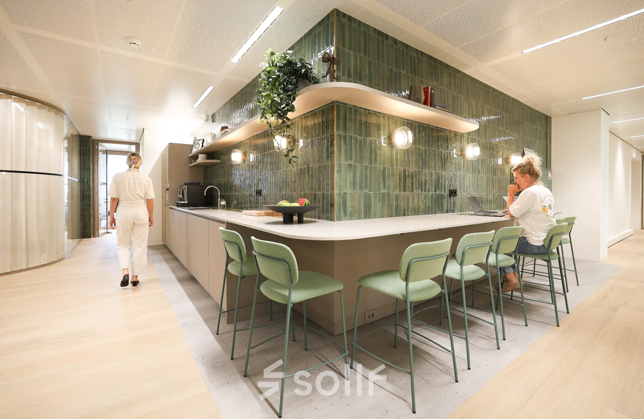 Moderne kantoorruimte huren aan Beethovenstraat 503 in Amsterdam Zuidas met een gemeubileerde kantoorpantry waar mensen zakelijke activiteiten uitvoeren.