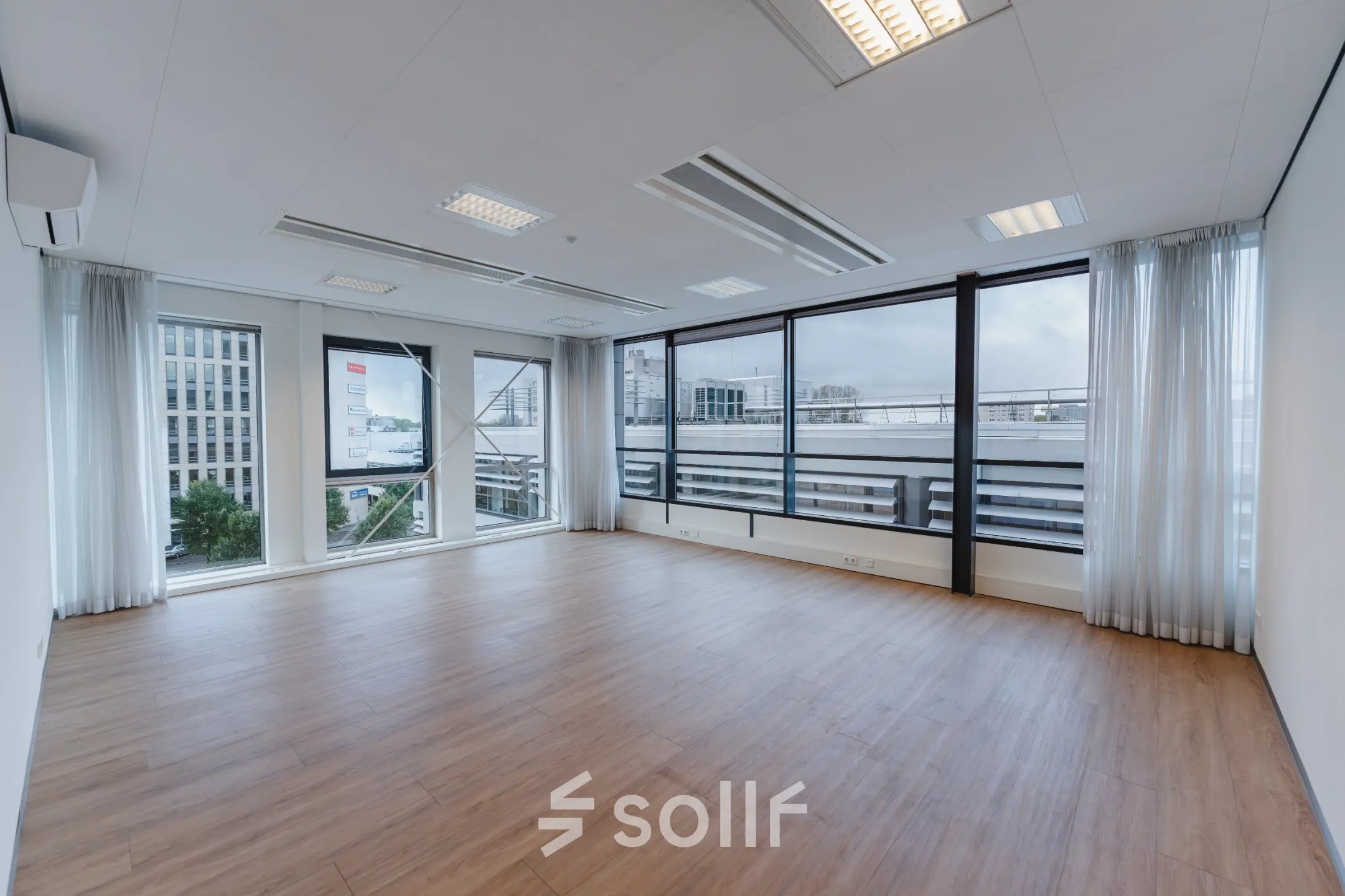 Leeg kantoor op De Boelelaan 30, Amsterdam Zuidas, met grote ramen en houten vloer. Ideaal voor kantoorruimte huren met uitzicht op de stad.