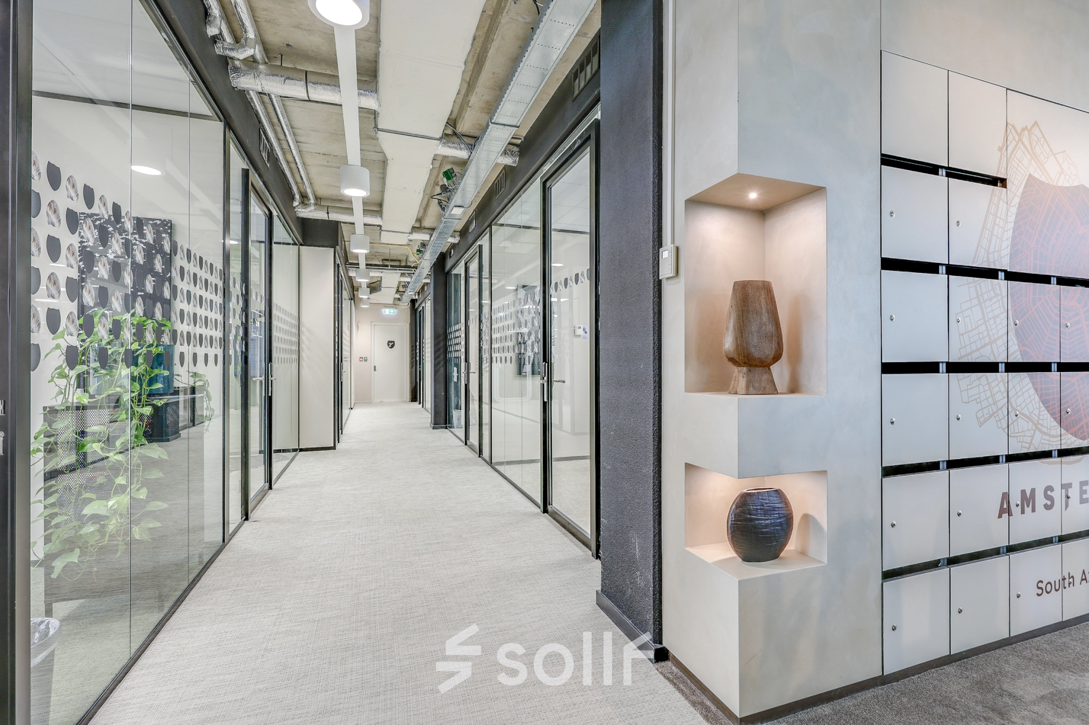 Heldere kantoorruimte aan de Gustav Mahlerlaan 308 in Amsterdam Zuidas met glazen wanden en decoratieve elementen. Ideaal voor wie kantoorruimte huren wil in een modern kantoorpand.
