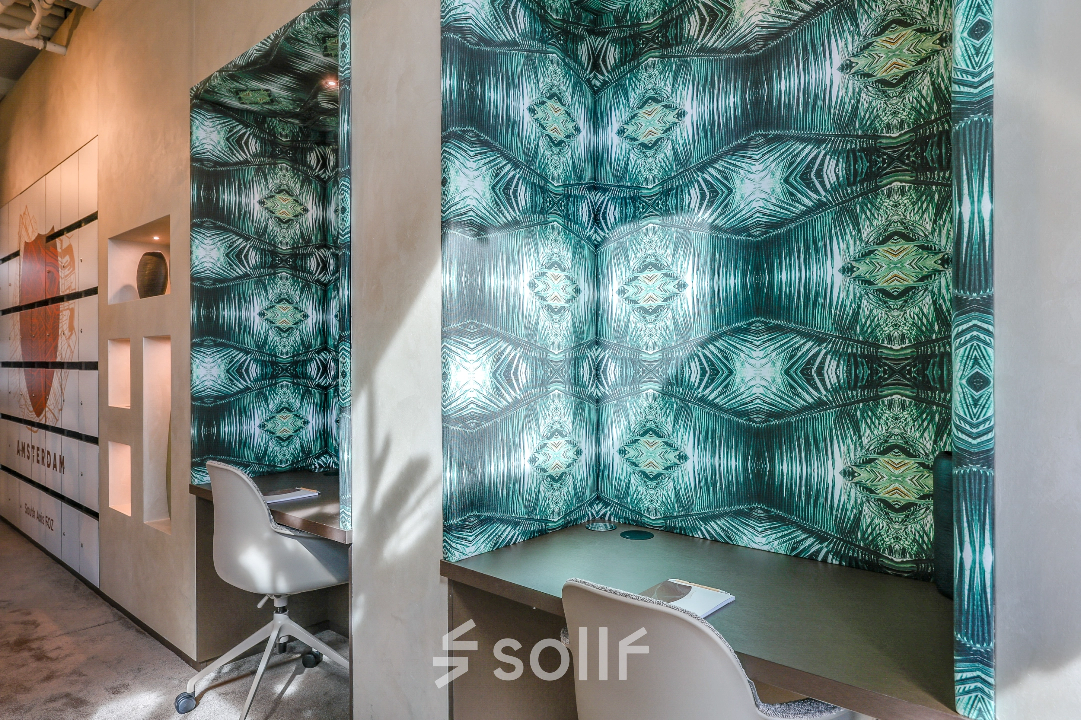 Moderne kantoorruimte te huur in Amsterdam Zuidas met stijlvolle wandbekleding en comfortabele bureaustoelen, ideaal voor productief werken.