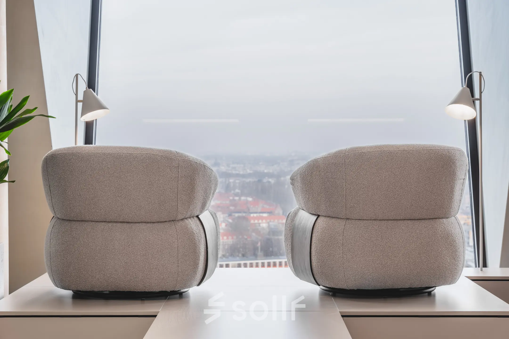 Moderne kantoorruimte met twee comfortabel ogende fauteuils en grote ramen met uitzicht over Amsterdam. Ideaal voor ontspannen vergaderingen of creatieve brainstormsessies in de Zuidas.