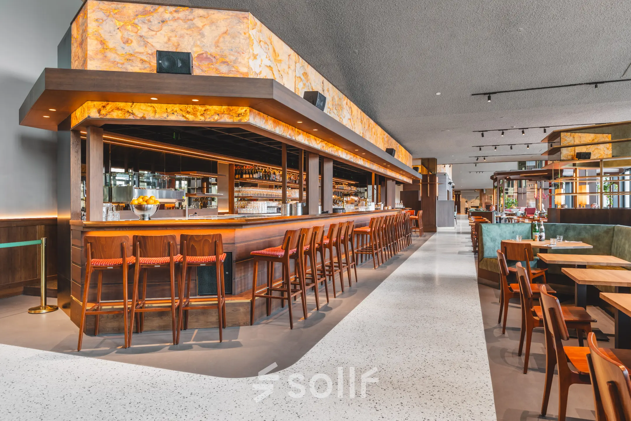 Moderne en stijlvolle bar met houten krukken en gezellige zitplekken in een kantoorpand in Amsterdam Zuidas.