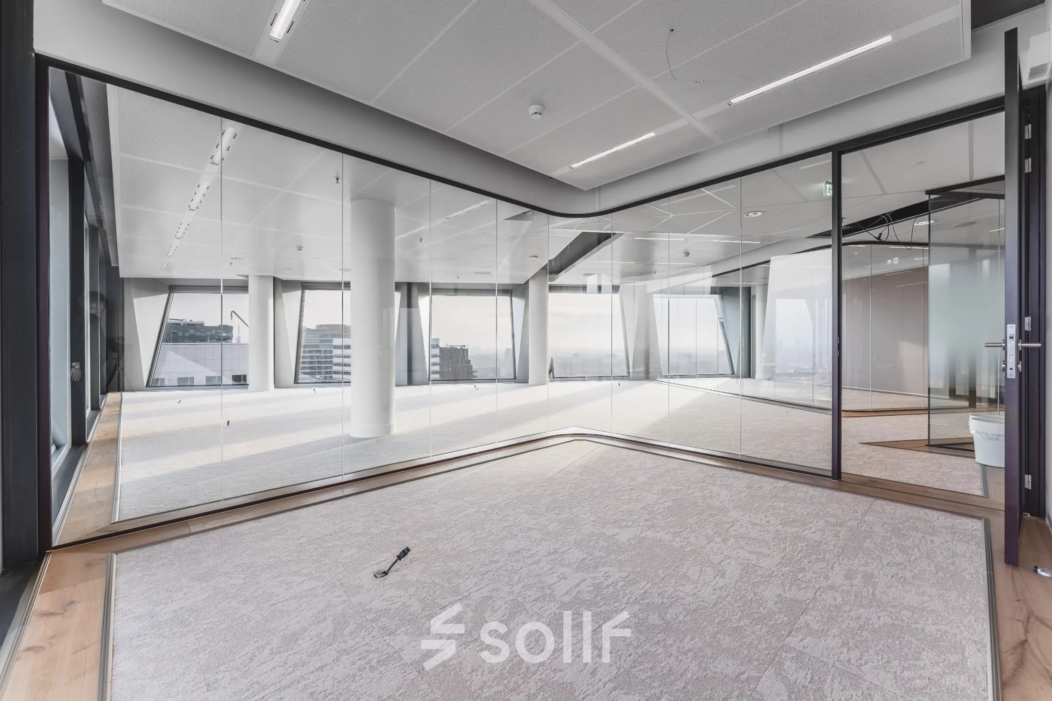 Lichte kantoorruimte te huur op Hildegard Von Bingenstraat 44 in Amsterdam Zuidas met glazen wanden en uitzicht op de stad.