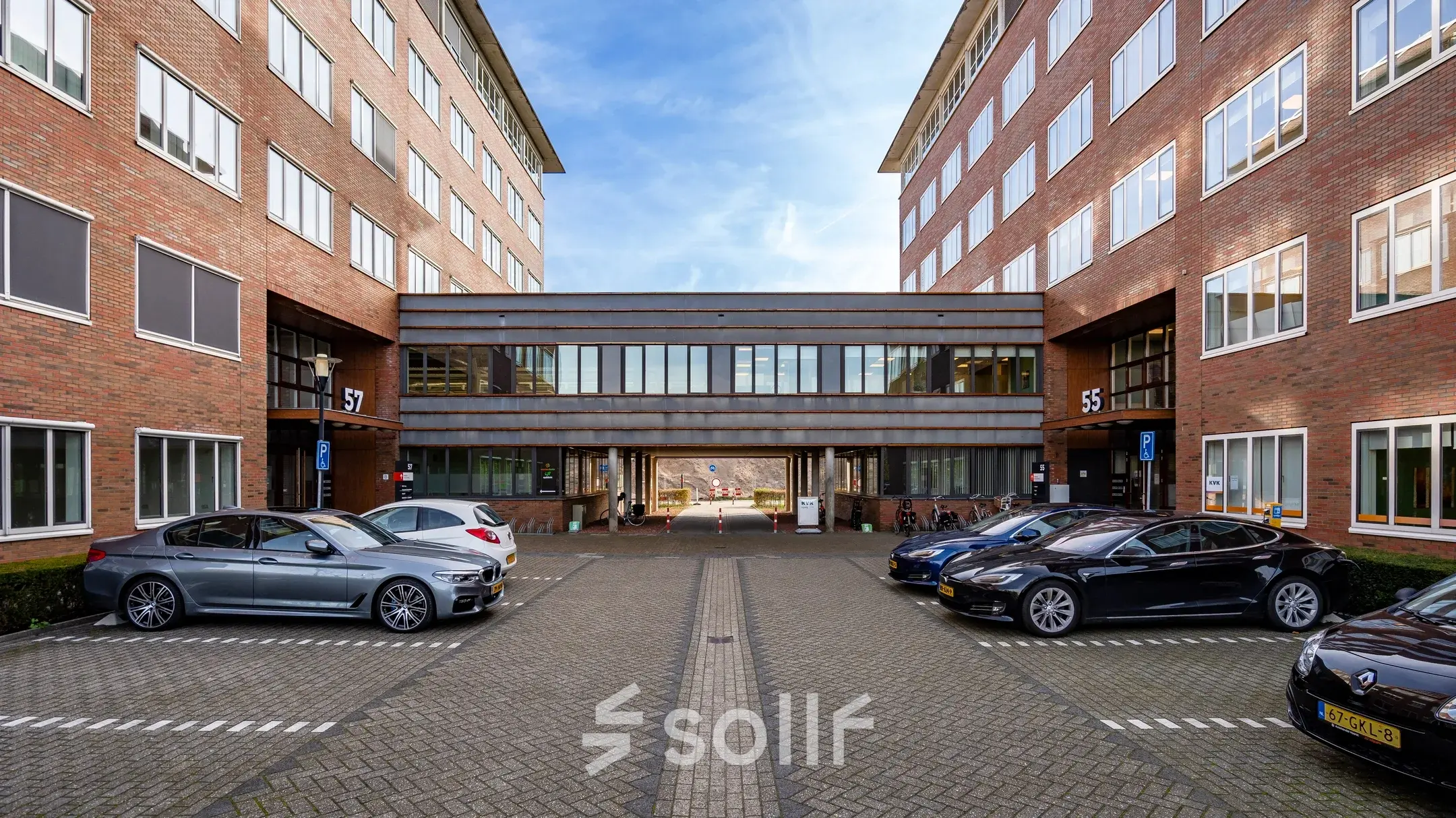 Kantoorpand Het Rietveld 55-59 in Apeldoorn met geparkeerde auto's op het terrein; ideaal voor kantoorruimte huren.