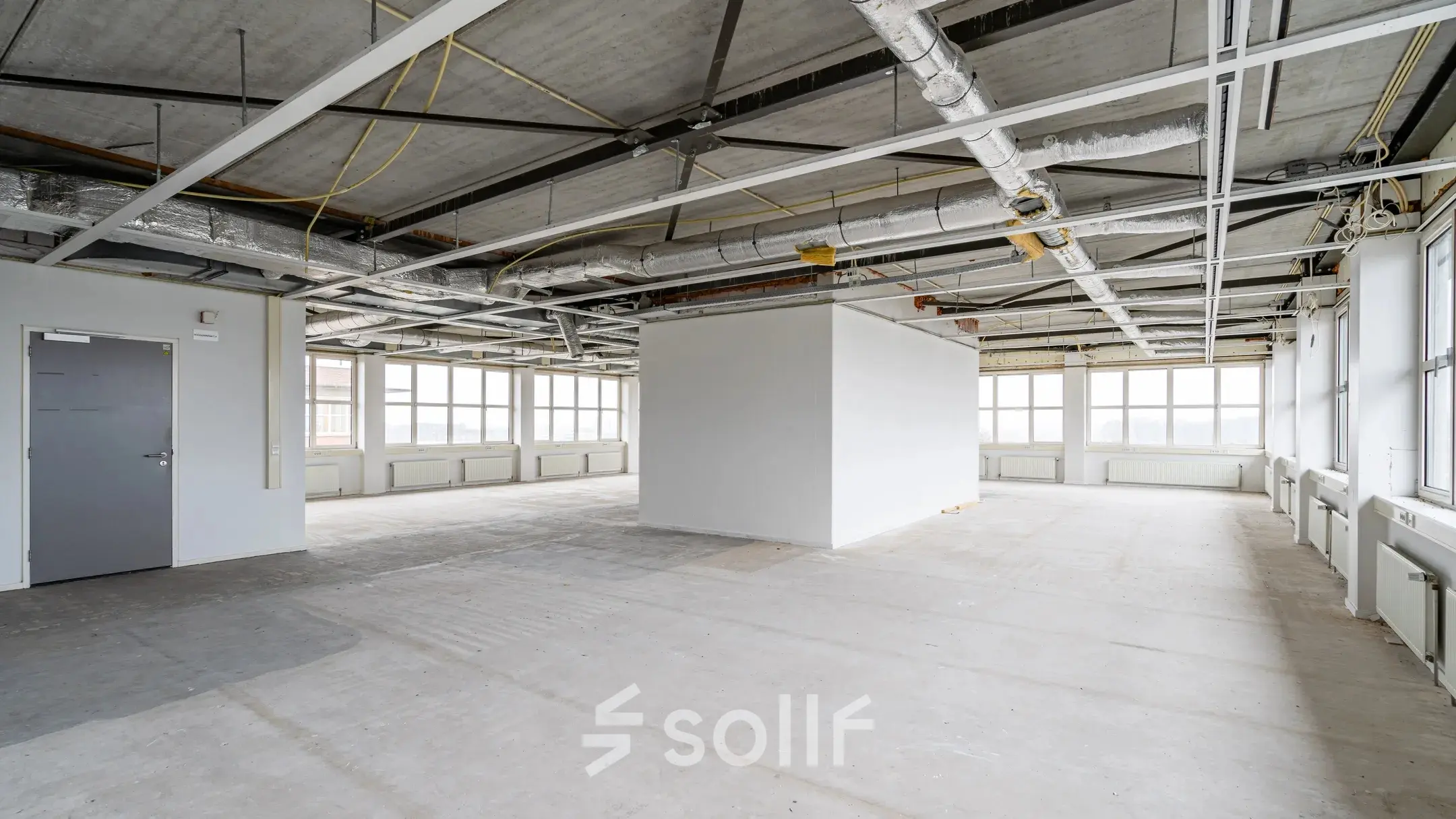 Ruime en lichte kantoorruimte te huur aan Het Rietveld 55-59 in Apeldoorn, met grote ramen en een open vloerplan, ideaal voor het creëren van een persoonlijke werkomgeving.