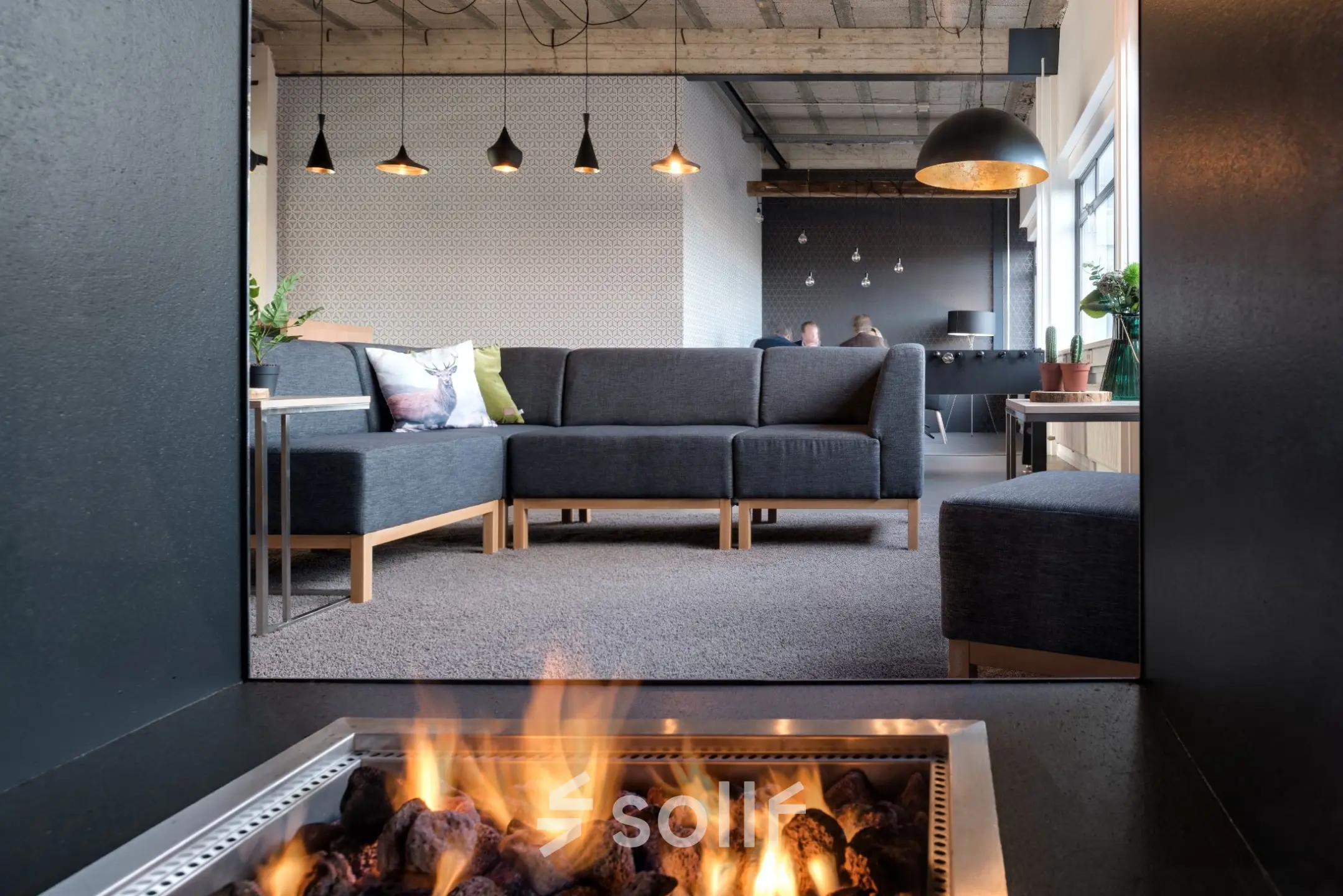 Moderne kantoorruimte huren op Oude Apeldoornseweg 41-45, Apeldoorn. Gemeubileerde lounge met comfortabele banken en sfeervolle verlichting. Personen voeren zakelijke gesprekken uit.