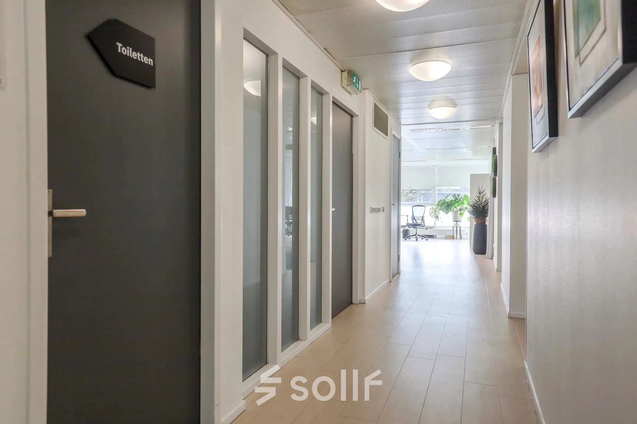 Lichte gang in kantoorpand aan Prins Willem-Alexanderlaan 301 in Apeldoorn, met houten vloer en toegang tot verschillende kantoorruimtes.