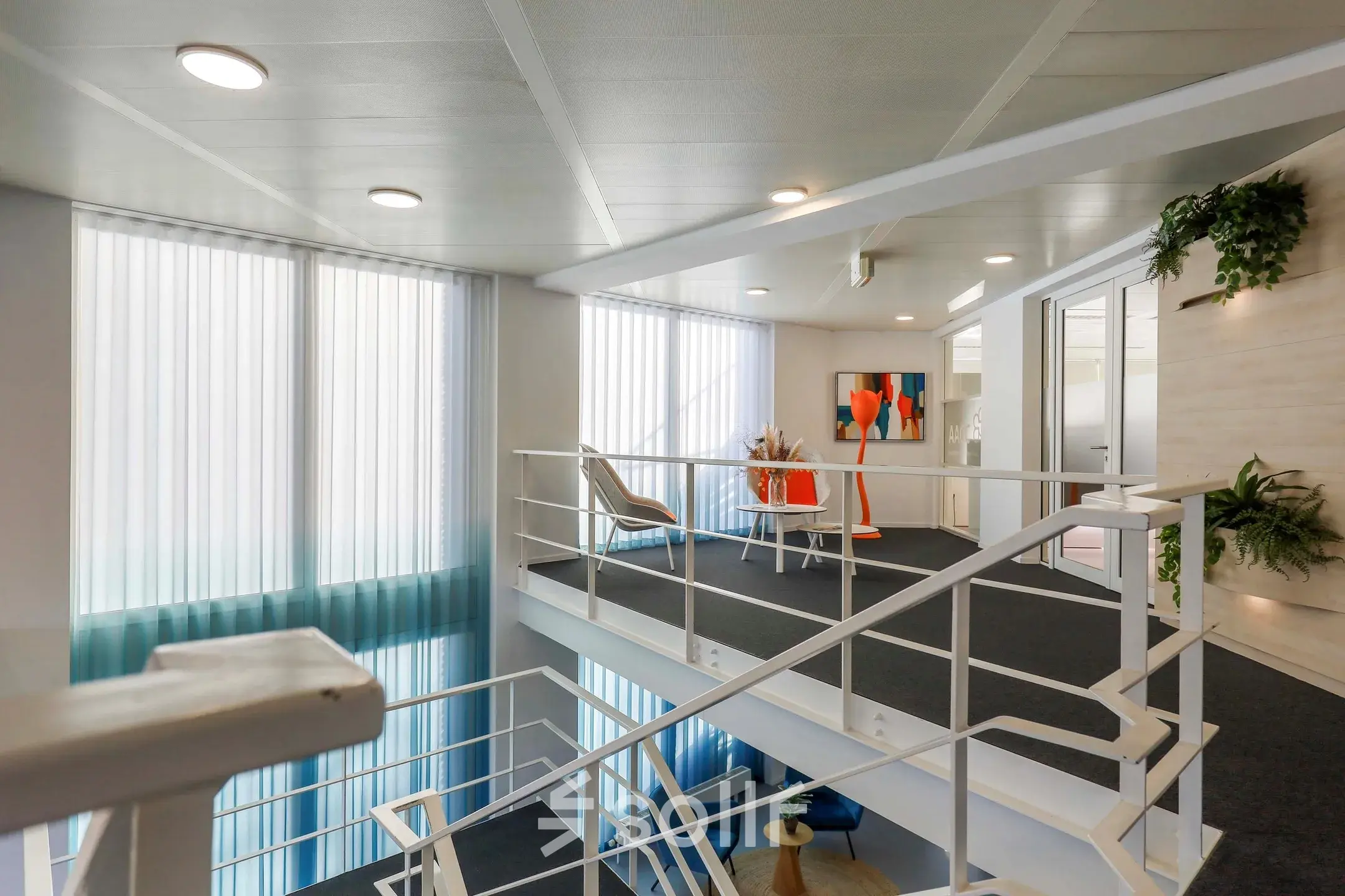 Moderne kantoorruimte te huur op de eerste verdieping van Prins Willem-Alexanderlaan 301 in Apeldoorn met strakke witte wanden en kunst aan de muur.