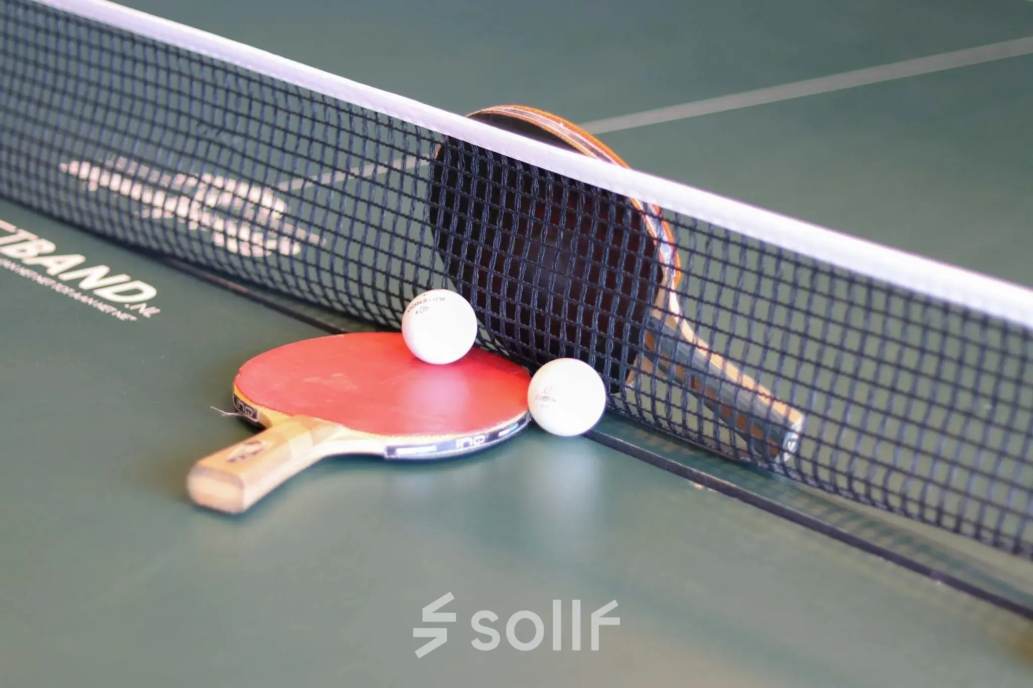 Tafeltennistafel met twee rackets en ballen in een kantoorpand aan Prins Willem-Alexanderlaan 401 in Apeldoorn voor ontspanning tijdens het werk.
