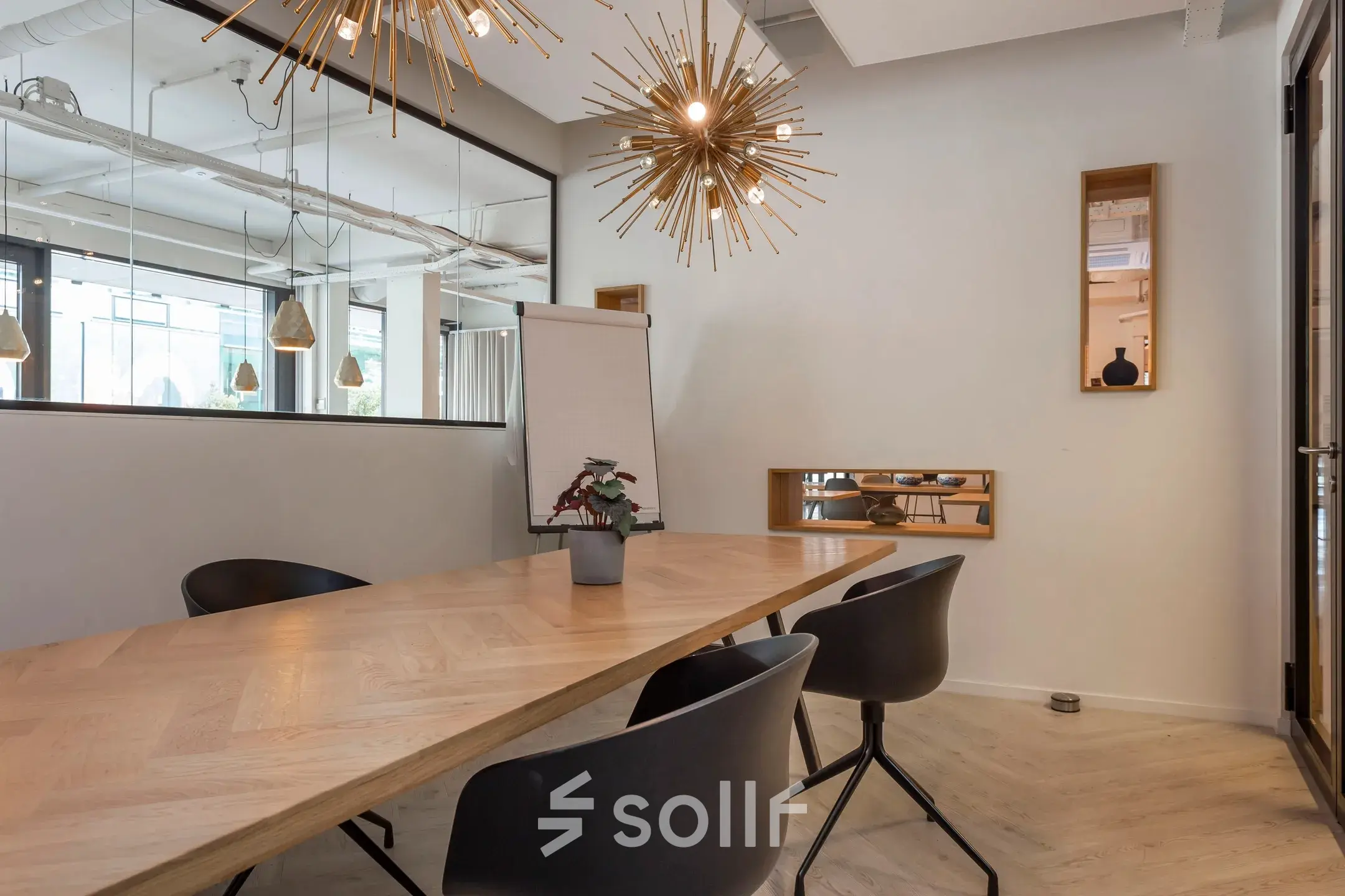 Stijlvolle kantoorruimte te huur op Roggestraat 111, Apeldoorn, met moderne verlichting, een houten tafel en comfortabele stoelen, ideaal voor vergaderingen in een kantoorpand.