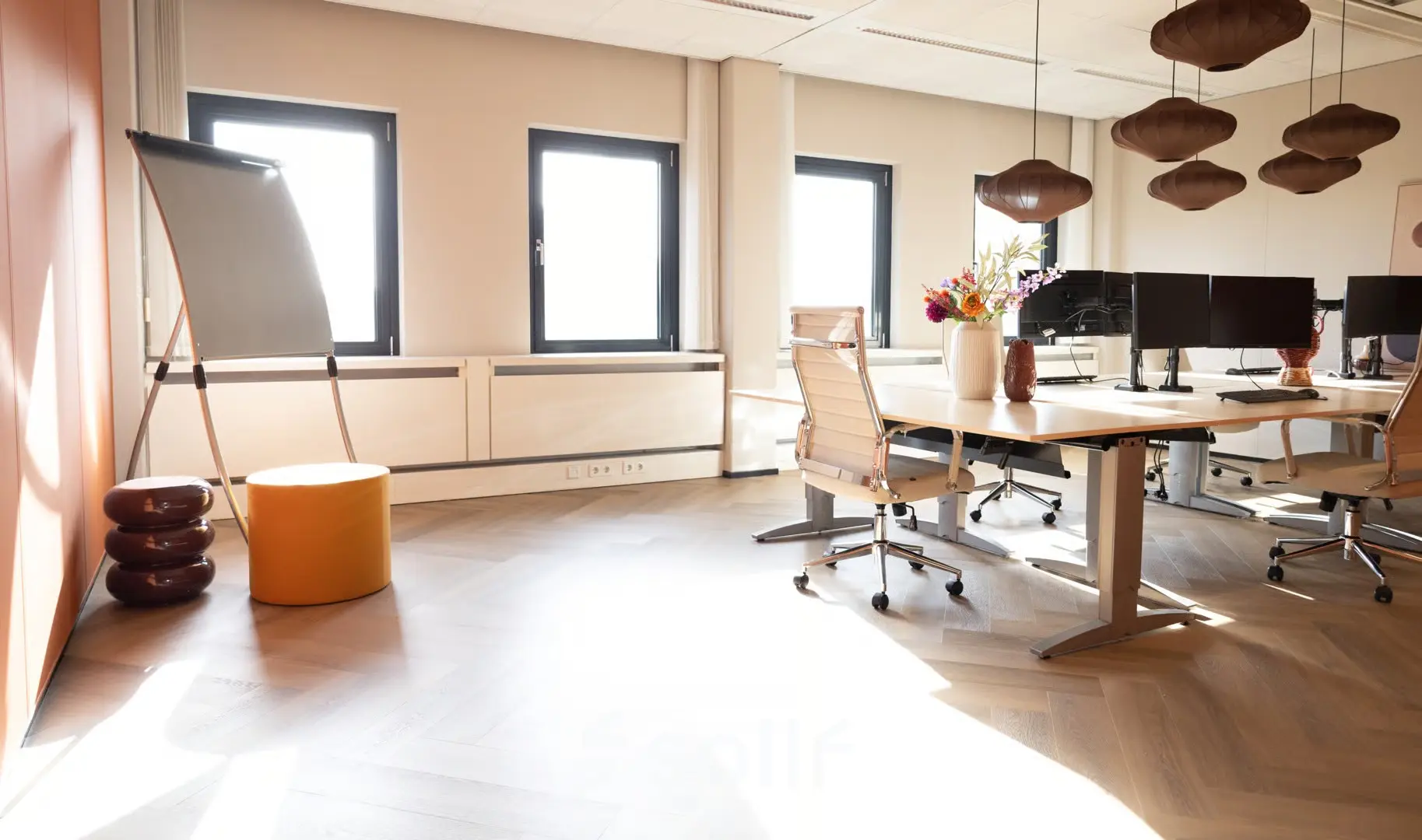 Kantoorruimte op Schumanpark 9 in Apeldoorn met moderne werkplekken, bureaustoelen en decoratieve verlichting, ideaal voor wie kantoorruimte wil huren.