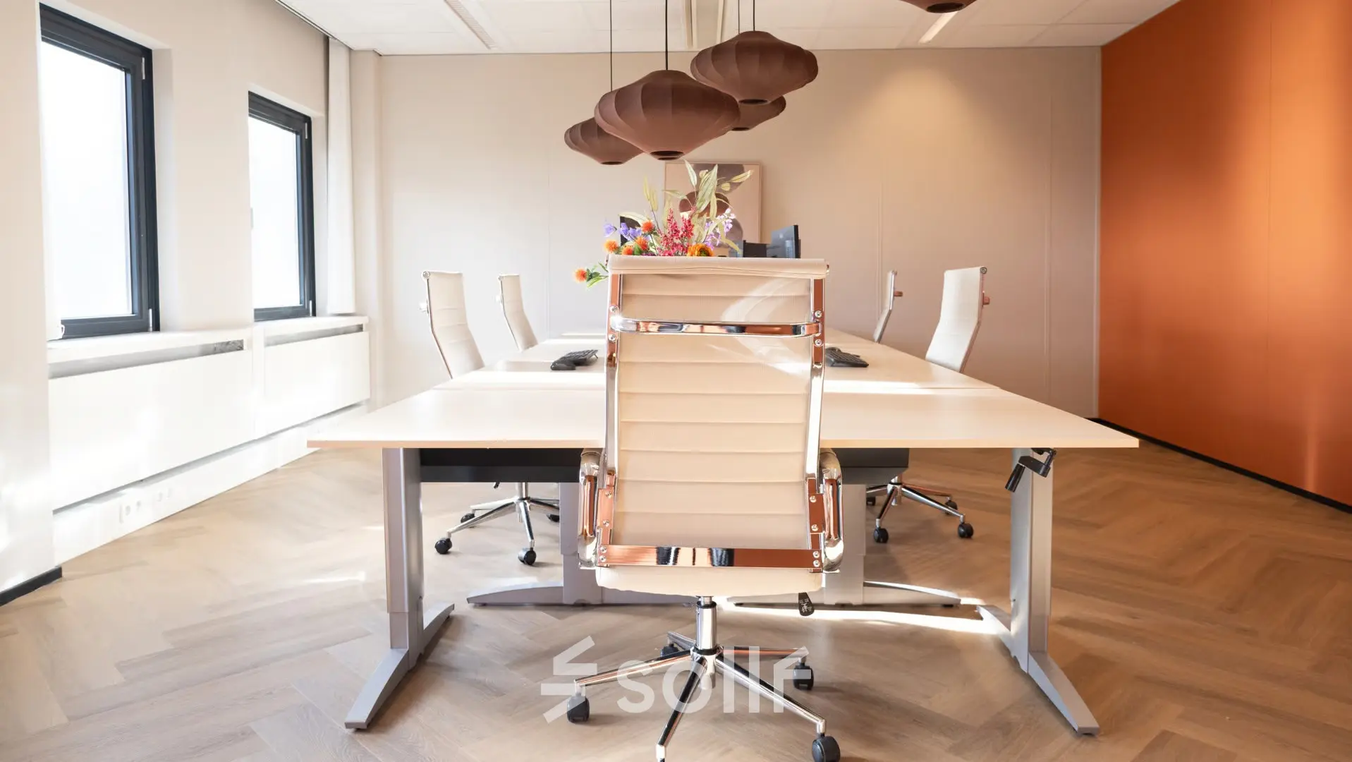 Lichte vergaderruimte in kantoorpand Schumanpark 9, Apeldoorn, met moderne stoelen en houten tafel.