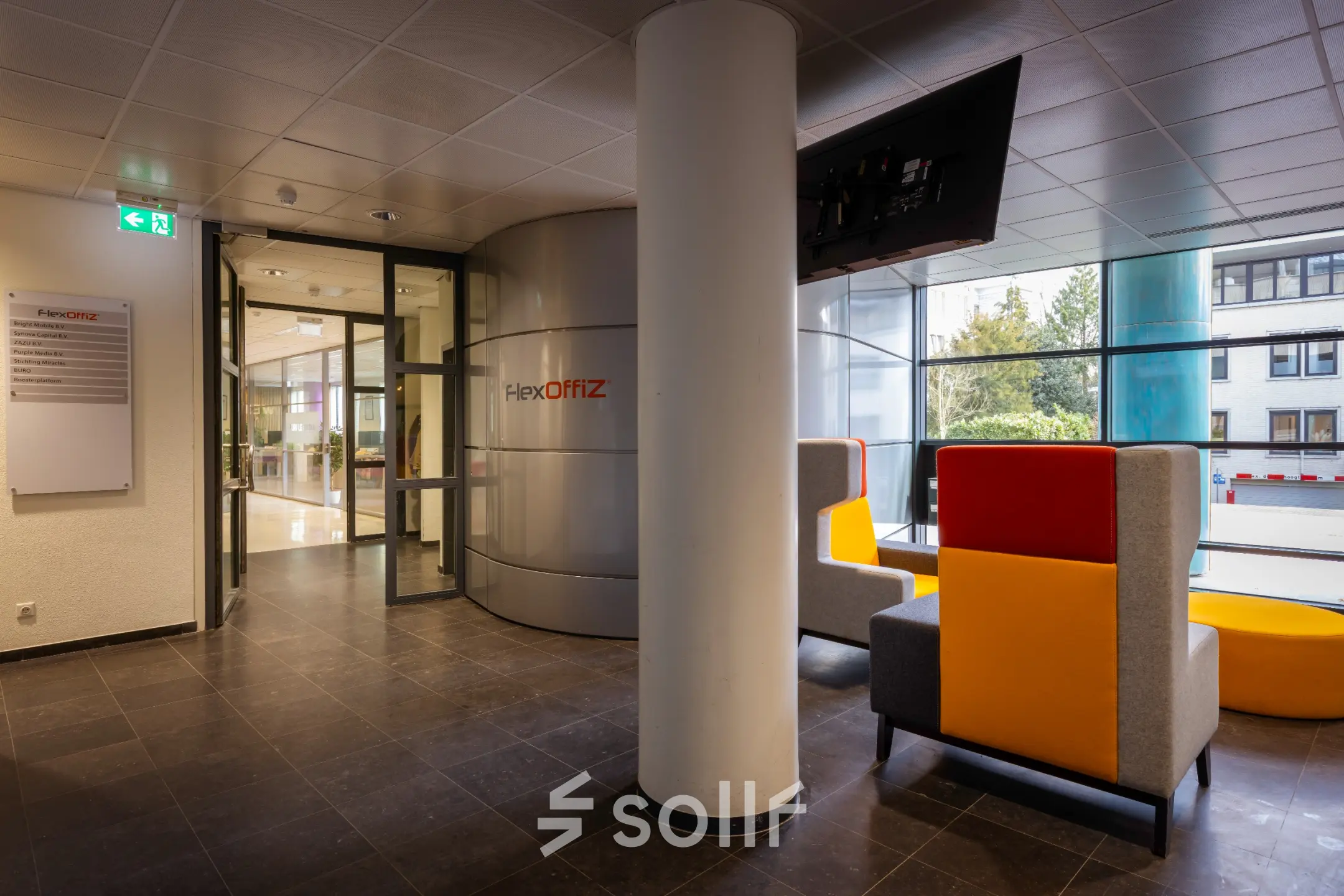 Kantoorruimte te huur in Baarn aan Amalialaan 126, met moderne ontvangsthal, kleurrijke zitplaatsen en glazen wanden voor een open uitstraling.