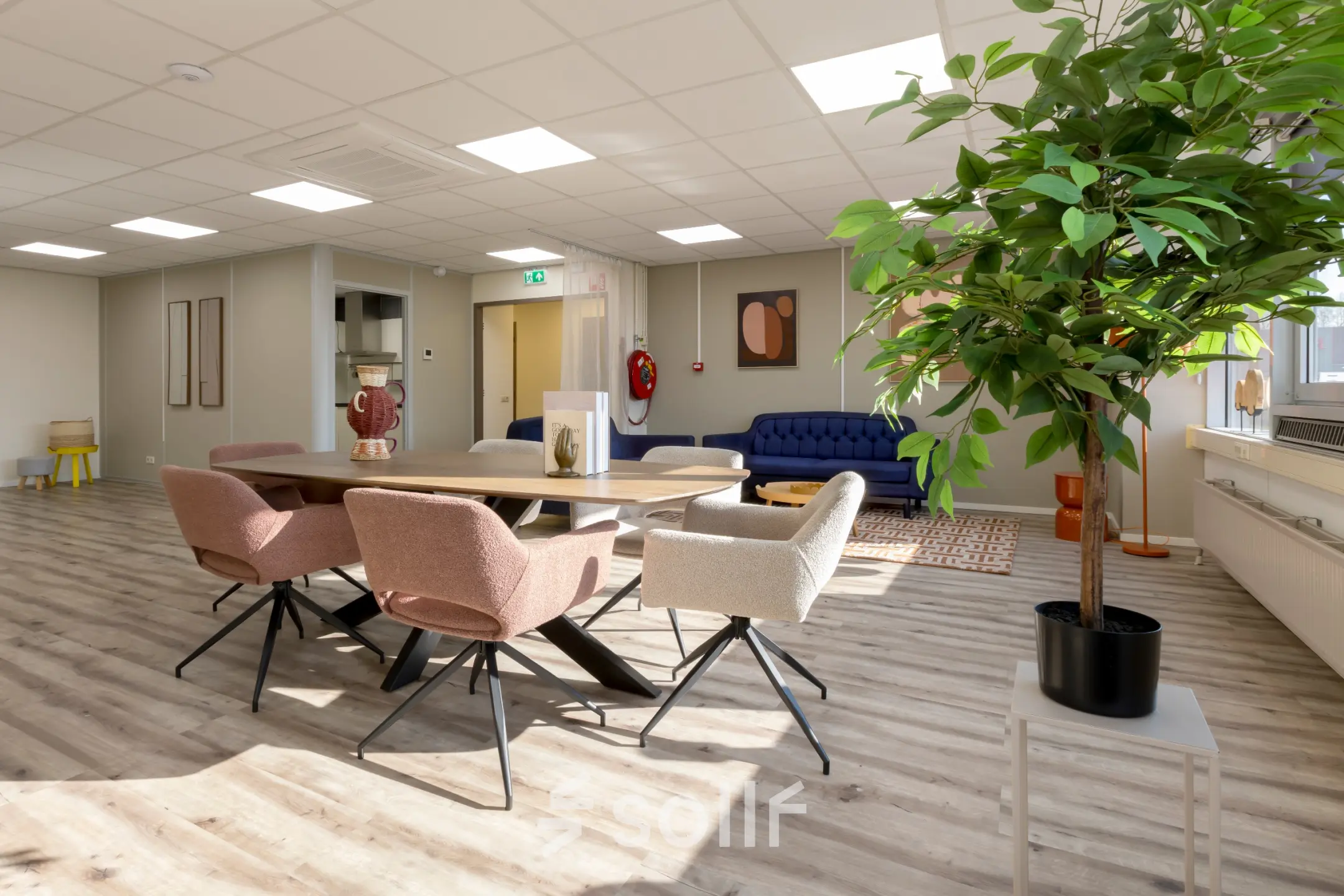 Gezellige werkruimte in een kantoor op Kamerlingh Onnesweg 10, Barendrecht met een tafel, stoelen, bank en planten. Ideale plek voor kantoorruimte huren.