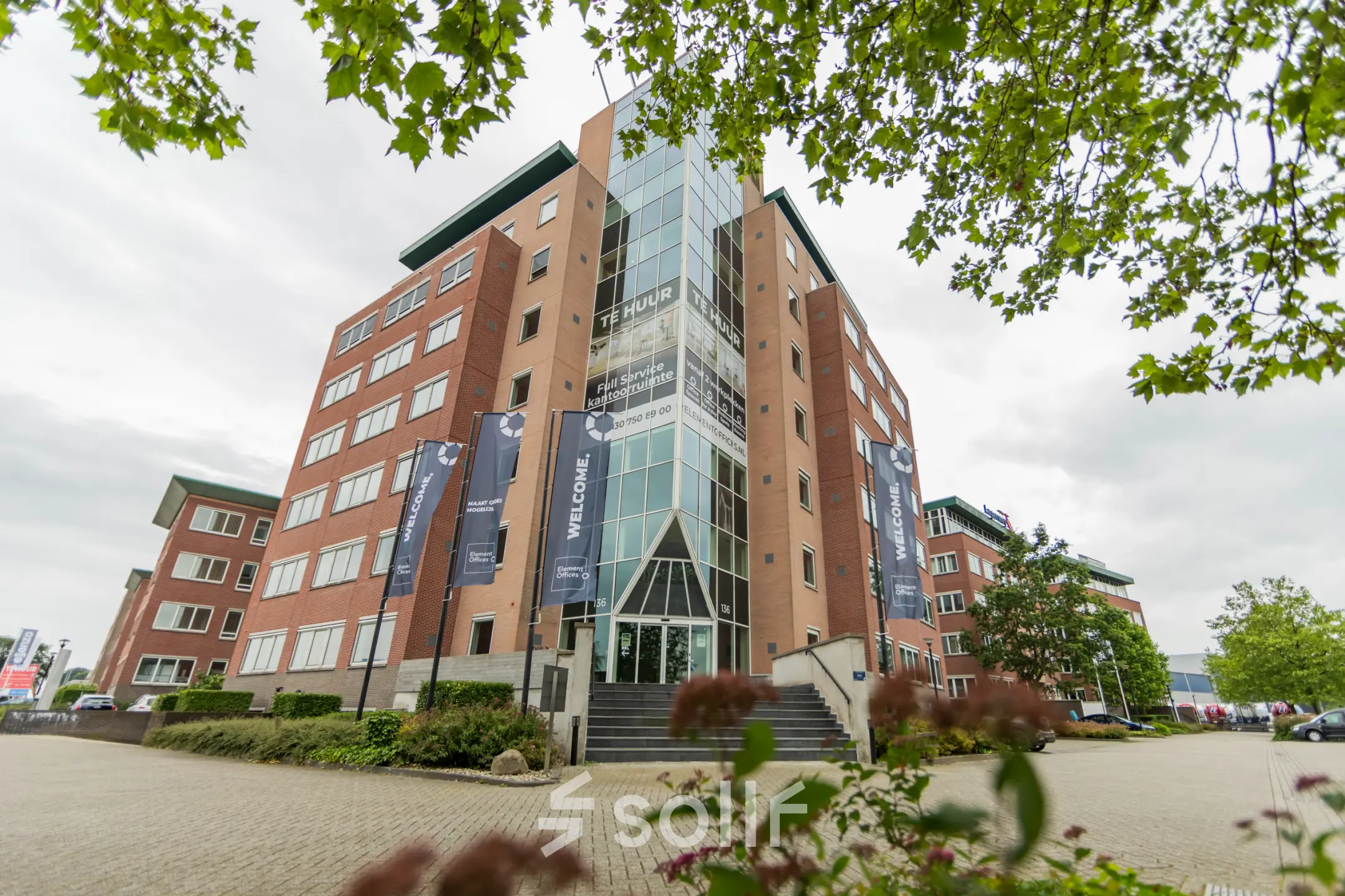 Buitenkant van een kantoorpand gelegen aan de Baron van Nagellstraat 136 in Barneveld. Het gebouw heeft meerdere verdiepingen en een entree met trappen, ideaal voor kantoorruimte huren.