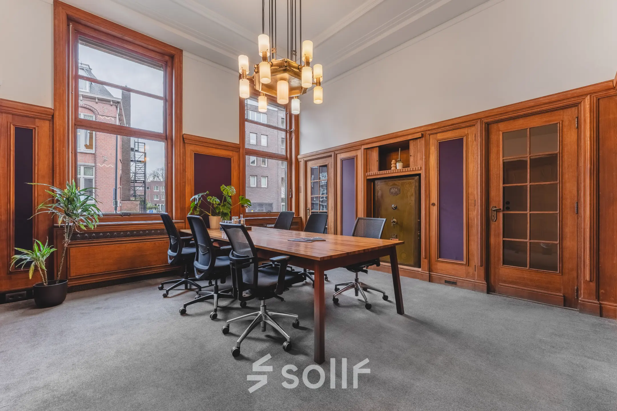 Kantoorruimte huren in Breda Centrum-Station op Ceresstraat 13 met een klassieke vergaderruimte, houten lambrisering, grote ramen en een lange tafel met stoelen.