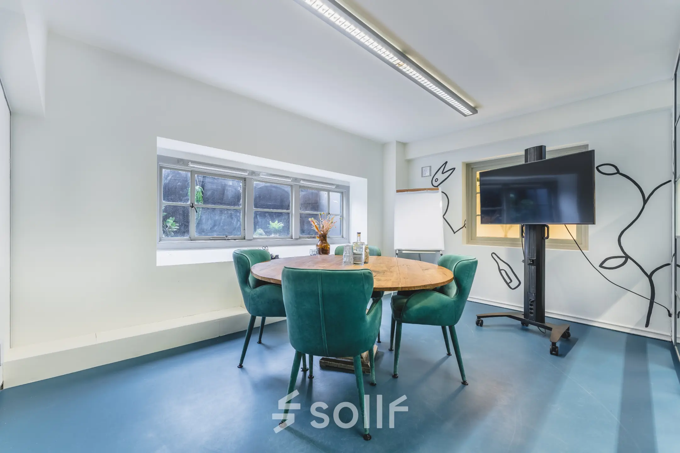 Moderne en lichte kantoorruimte met ronde tafel, comfortabele stoelen en een groot scherm, ideaal voor vergaderingen. Beschikbaar voor huur op Ceresstraat 13 in Breda Centrum-Station.