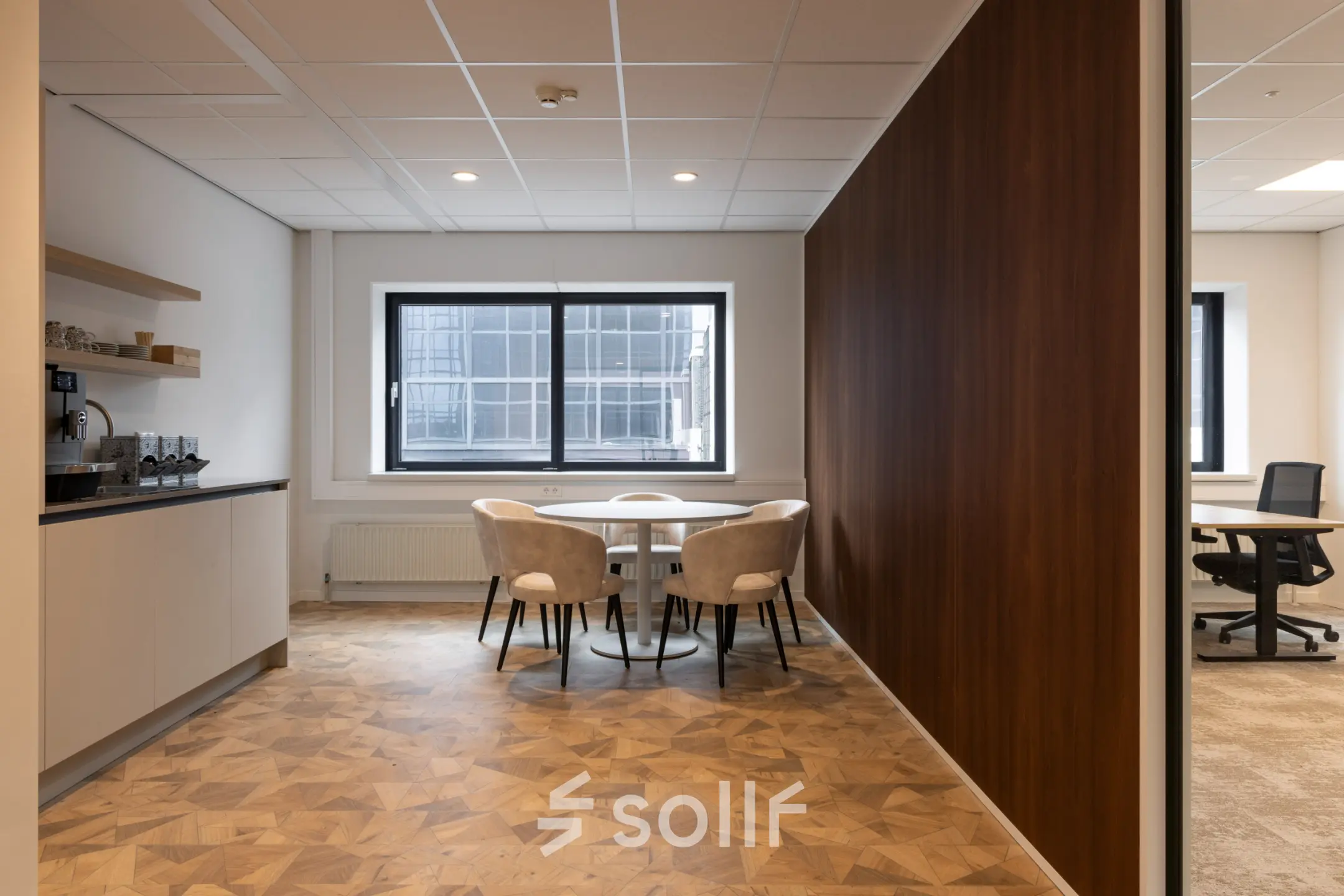 Kantoorruimte huren op Essebaan 63, Capelle aan den IJssel, met een moderne inrichting. De ruimte bevat een tafel met stoelen en een kitchenette.