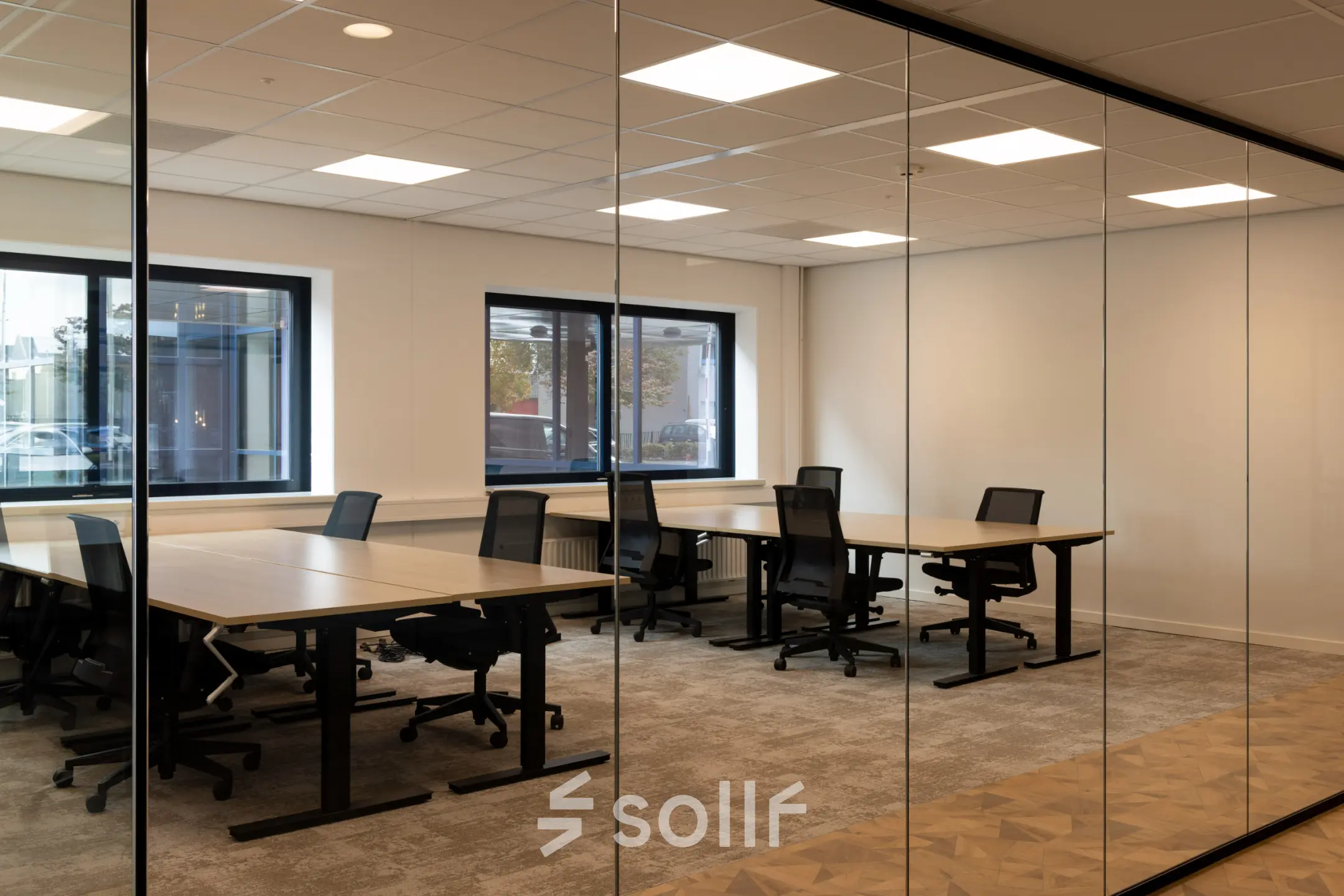 Moderne kantoorruimte met glazen wanden, voorzien van werkplekken met bureaus en ergonomische stoelen, te huur aan Essebaan 63, Capelle aan den IJssel.