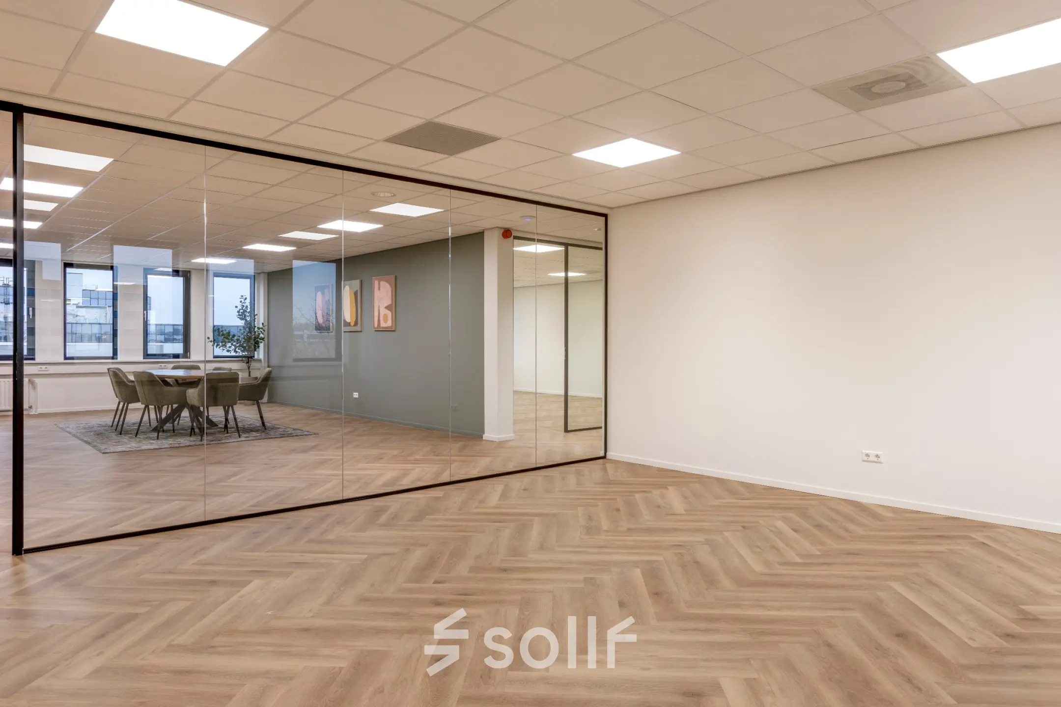 Moderne kantoorruimte aan de Vlierbaan 20, Capelle aan den IJssel, met houten vloer en glazen wand. Ideaal voor bedrijven om kantoor te huren. Grote ramen zorgen voor veel natuurlijk licht.