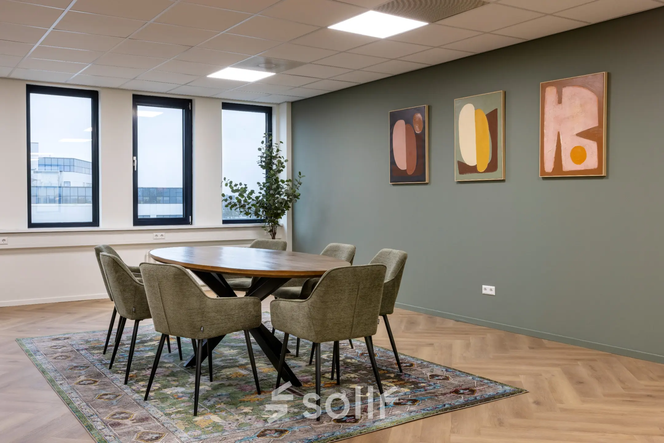 Kantoorruimte op Vlierbaan 20, Capelle aan den IJssel met een stijlvolle vergadertafel, zes stoelen en kunstwerken aan de muur.