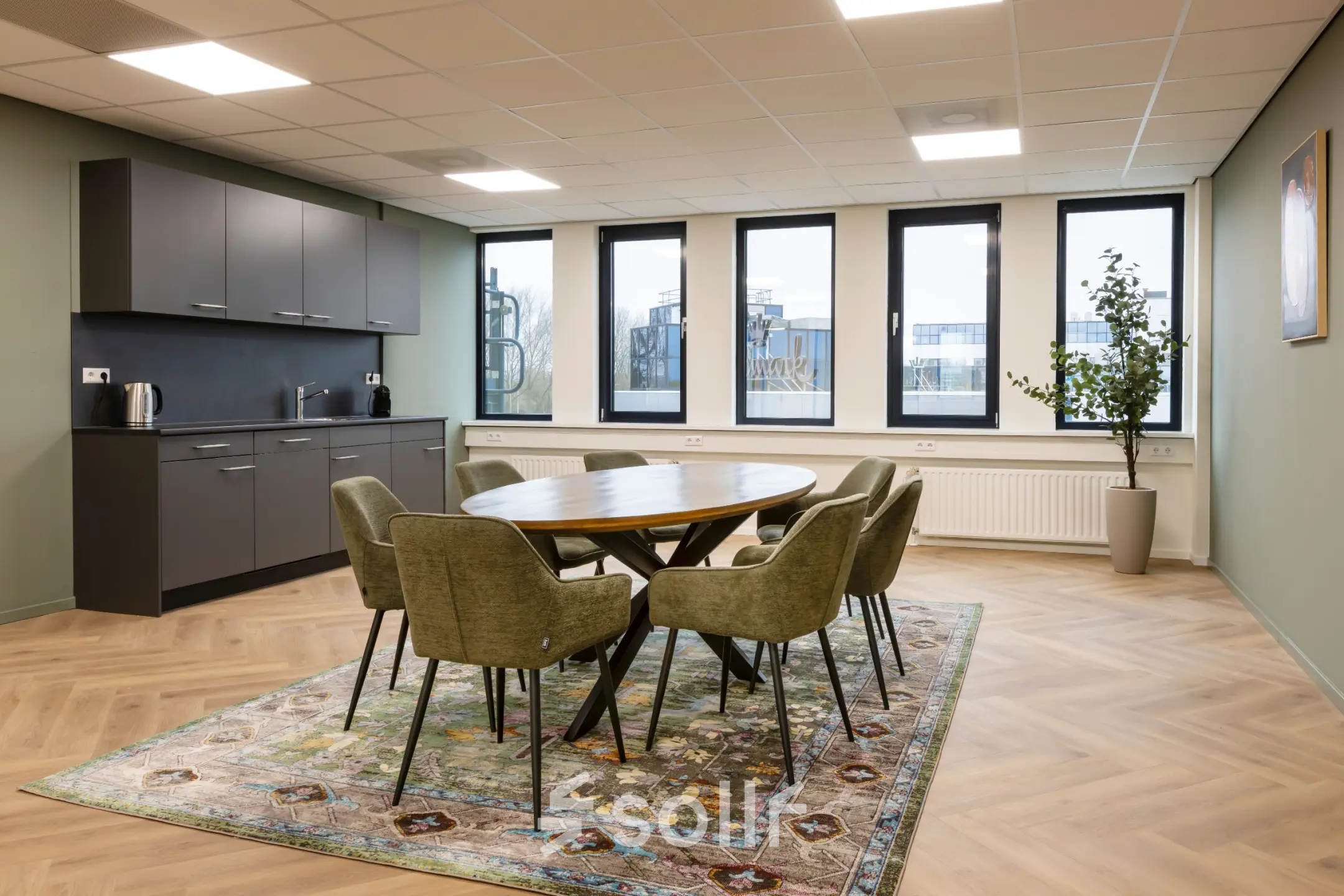 Moderne kantoorruimte met ronde tafel en zes stoelen, vlakbij het raam, op Vlierbaan 20. Voorzien van een kitchenette. Ideaal voor wie kantoorruimte wil huren in Capelle aan den IJssel.
