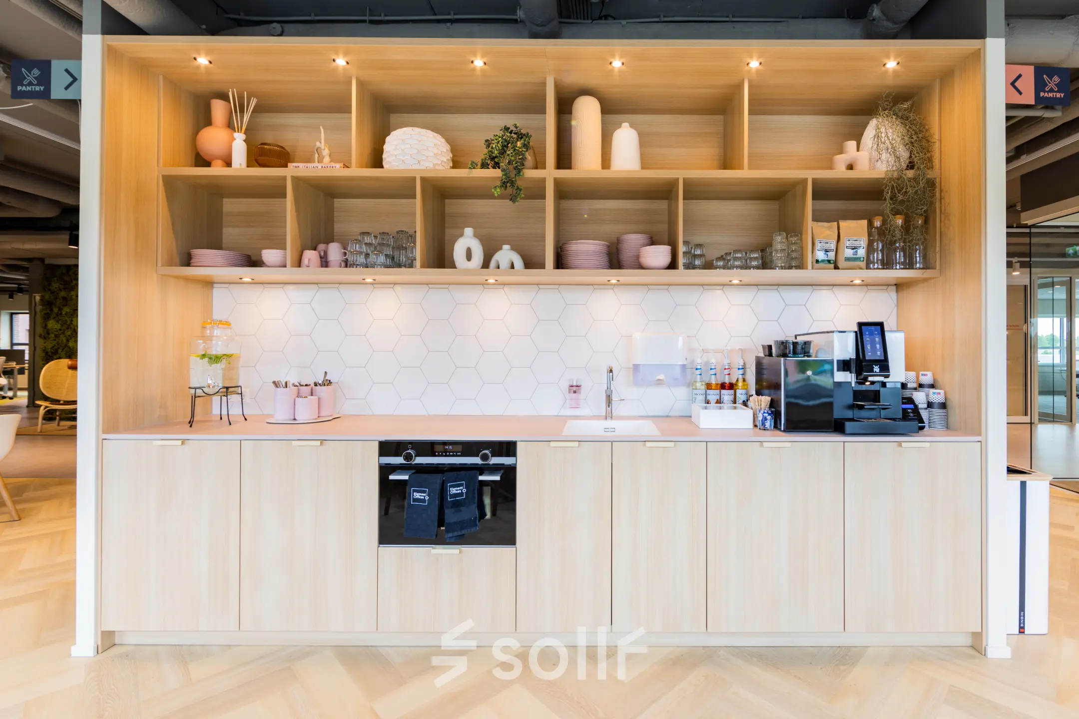 Stijlvolle pantry met houten kasten en moderne apparatuur in een kantoorpand op Rijnzathe 12, De Meern. Ideaal voor een pauze tijdens het kantoorwerk. Overweeg deze ruimte te huren.