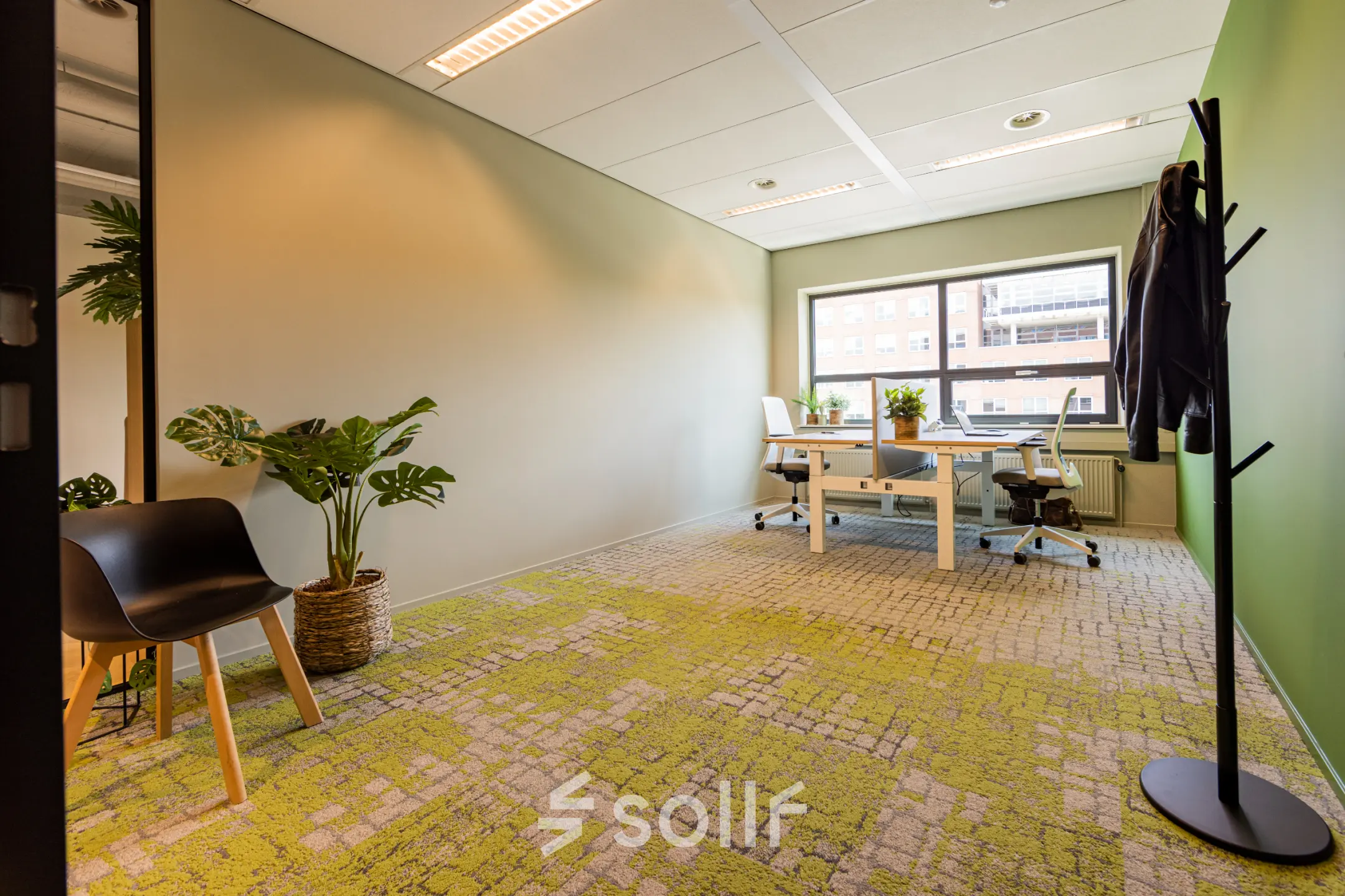 Kantoorruimte huren in een modern ingericht kantoorpand op Rijnzathe 12, De Meern. De lichte werkruimte heeft grote ramen en twee bureaus met stoelen, met planten die een frisse uitstraling geven.