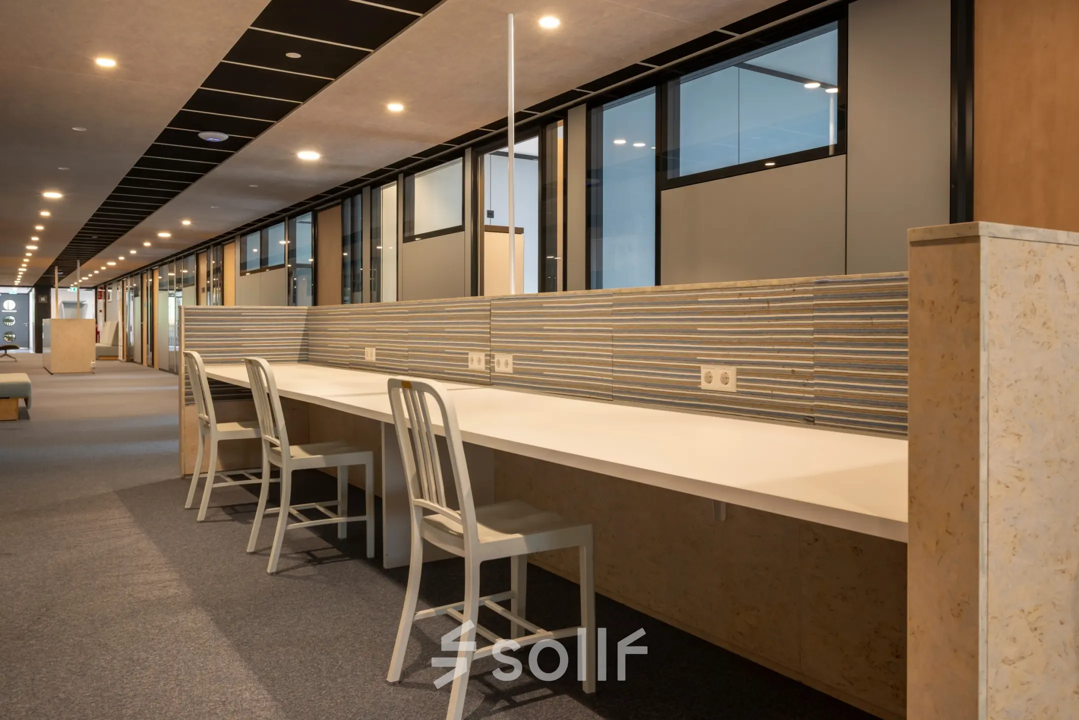 Moderne kantoorruimte huren op Delftechpark 9 in Delft, met lange werktafels en comfortabele stoelen, ideaal voor efficiënt kantoorwerk.