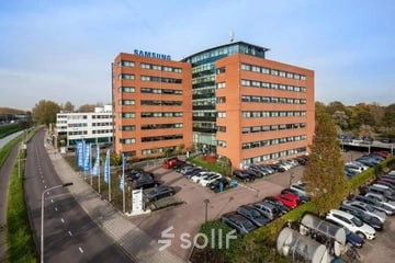 Buitenaanzicht van het kantoorpand aan de Olof Palmerstraat 10 in Delft, met meerdere verdiepingen en parkeerplaatsen, ideaal voor kantoorruimte huren.