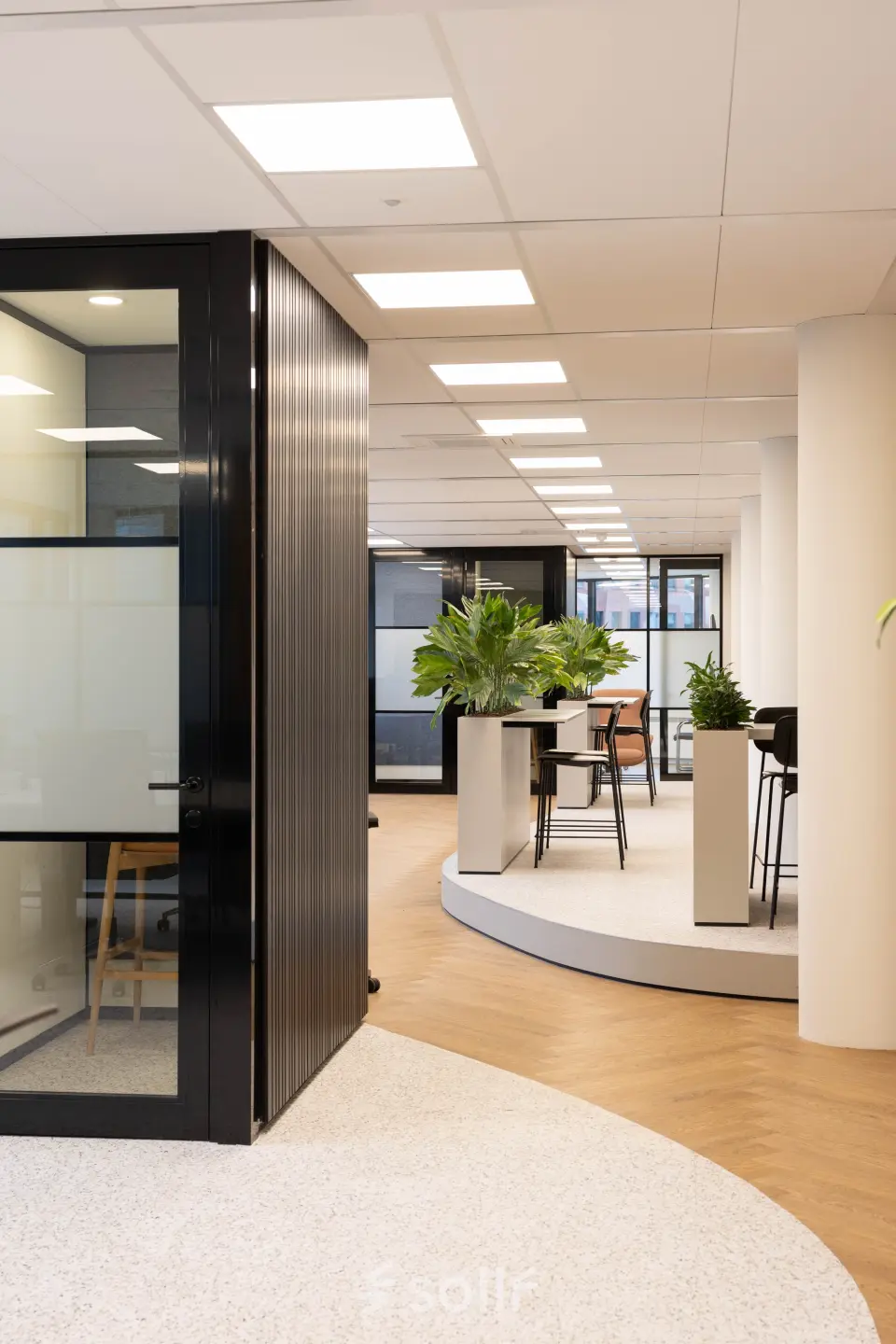 Moderne kantoorruimte met glazen wanden en groene planten op Hambakenwetering 1, Den Bosch. Ideaal om een kantoorpand te huren met stijlvol interieur en ruime werkplekken.