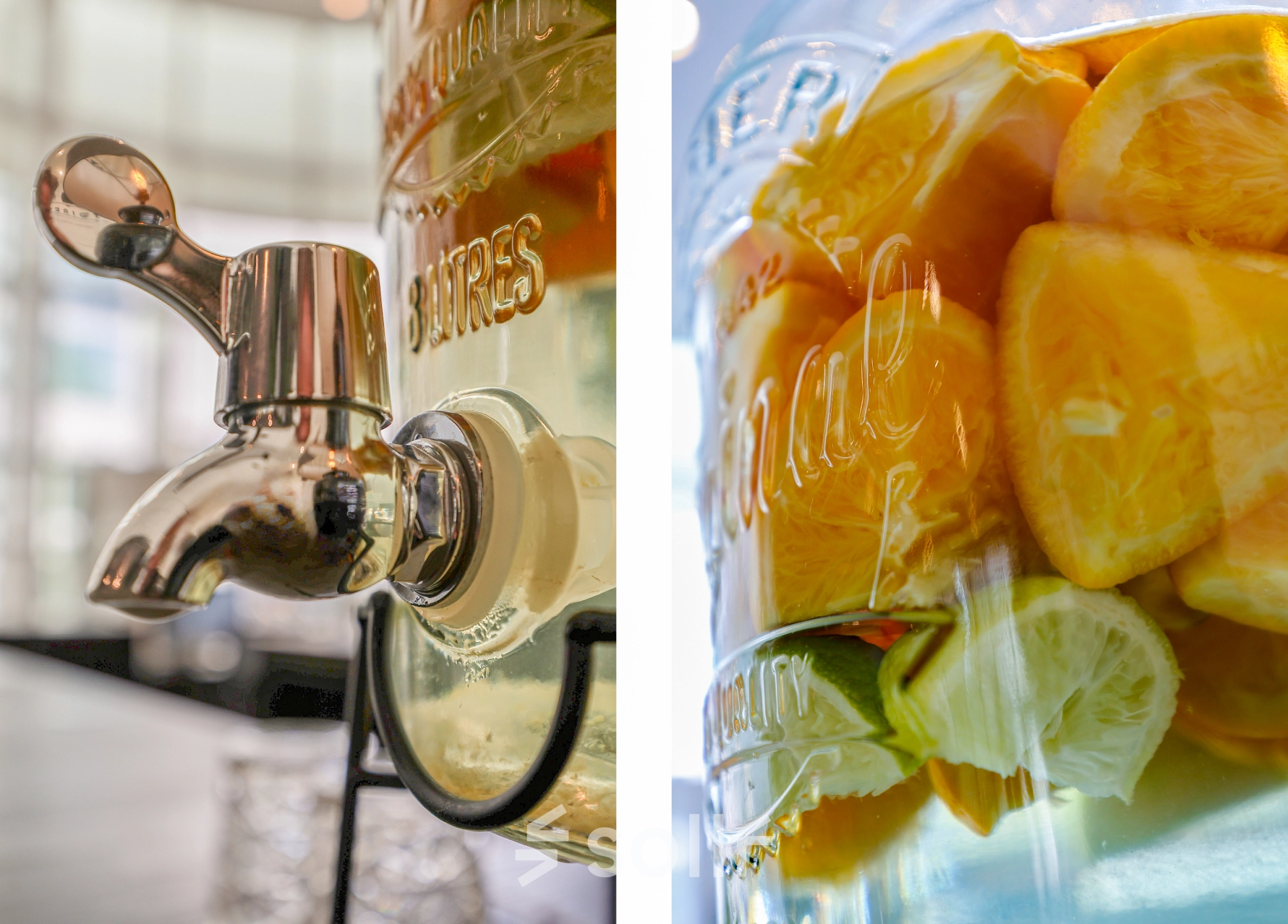 Close-up van een glazen dispenser gevuld met schijfjes sinaasappel en limoen, geschikt voor verfrissend water in een kantoorruimte op Kalvermarkt 53, Den Haag Centrum.