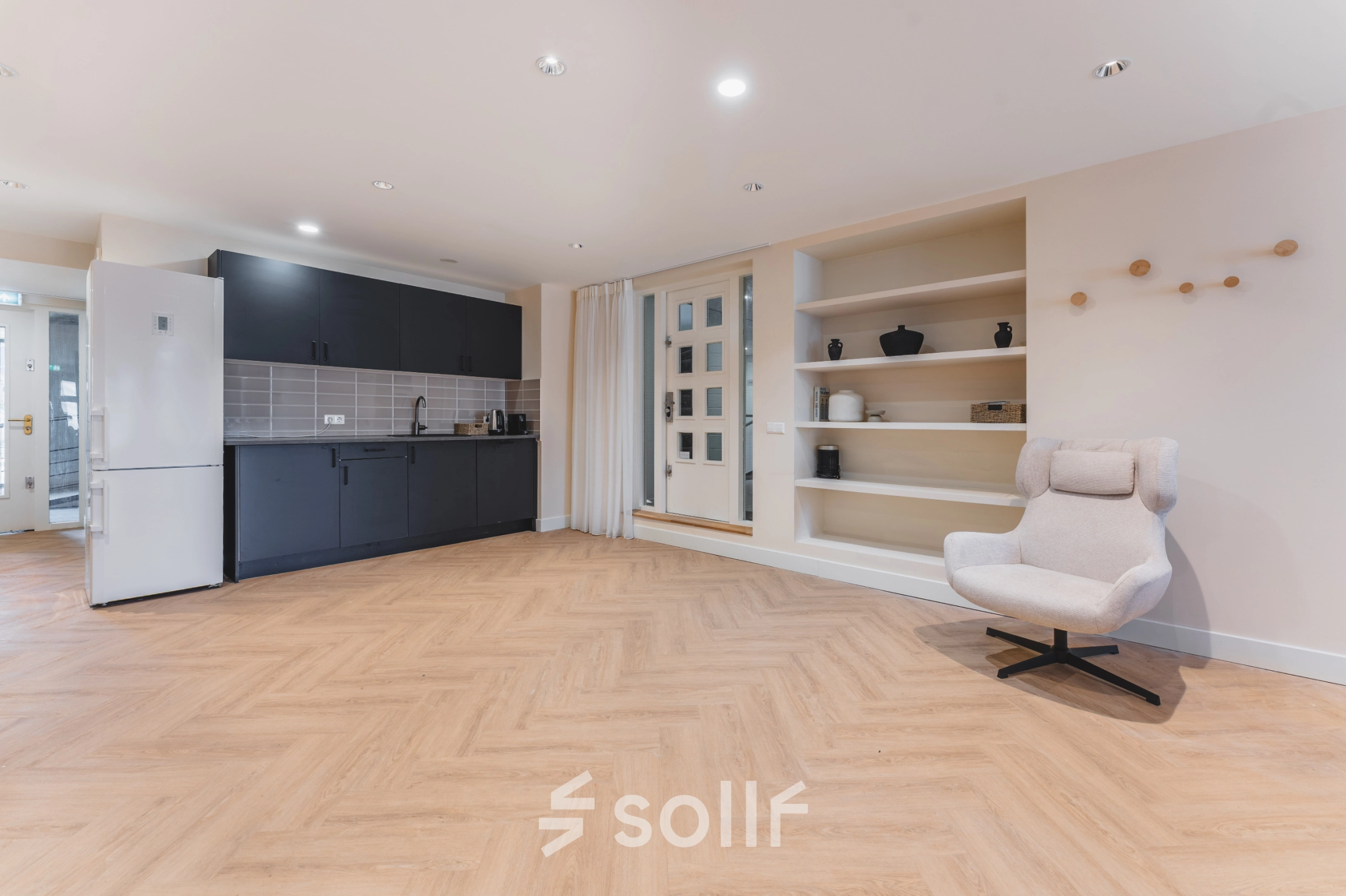 Deze kantoorruimte aan de Zeestraat 100 in Den Haag Centrum beschikt over een modern ingerichte pantry met stijlvolle keukenkasten en comfortabele stoel, ideaal om te huren voor informele werkpauzes.