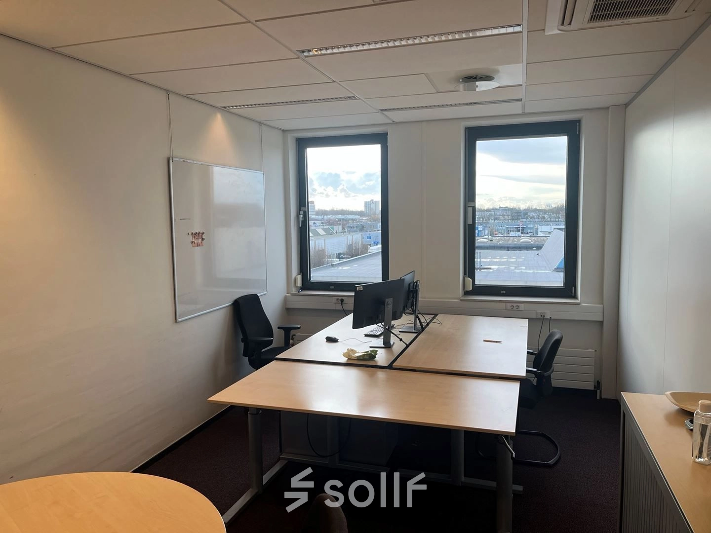 Kantoorruimte huren in kantoorpand op Platinaweg 10, Den Haag Escamp. Gezellige werkplek met twee bureaus en stoelen, grote ramen voor natuurlijk licht. Ideaal voor productief werken.