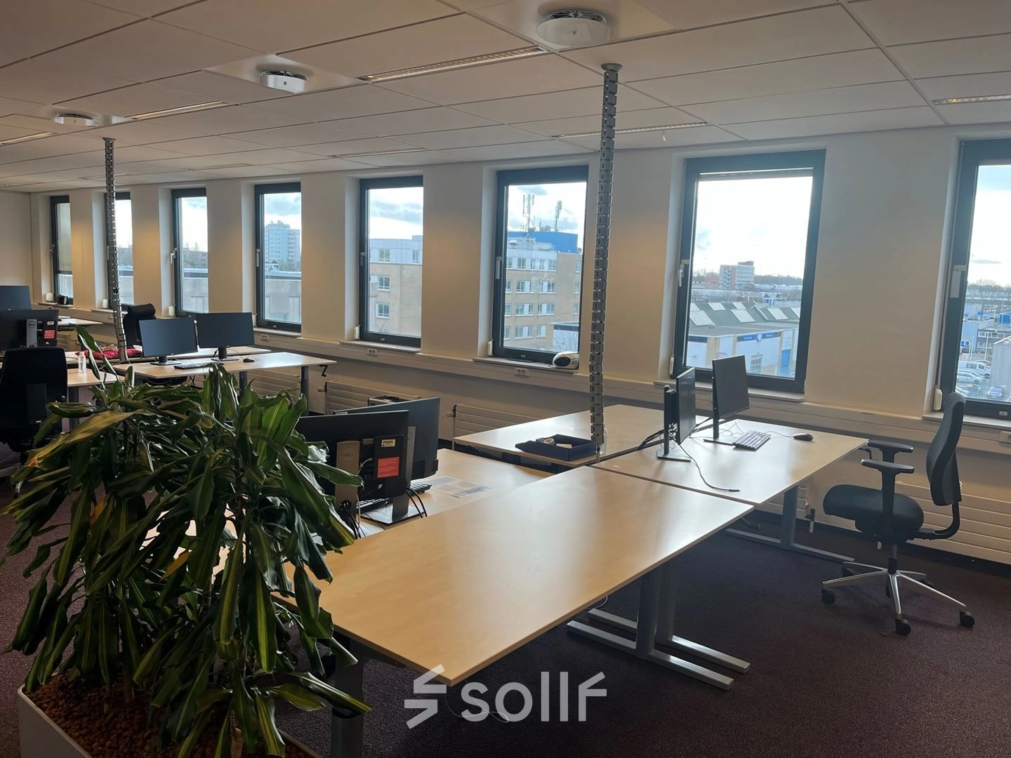 Lichte kantoorruimte met grote ramen en werkplekken aan de Platinaweg 10 in Den Haag Escamp, ideaal voor kantoorruimte huren met een modern interieur en uitzicht op de stad.