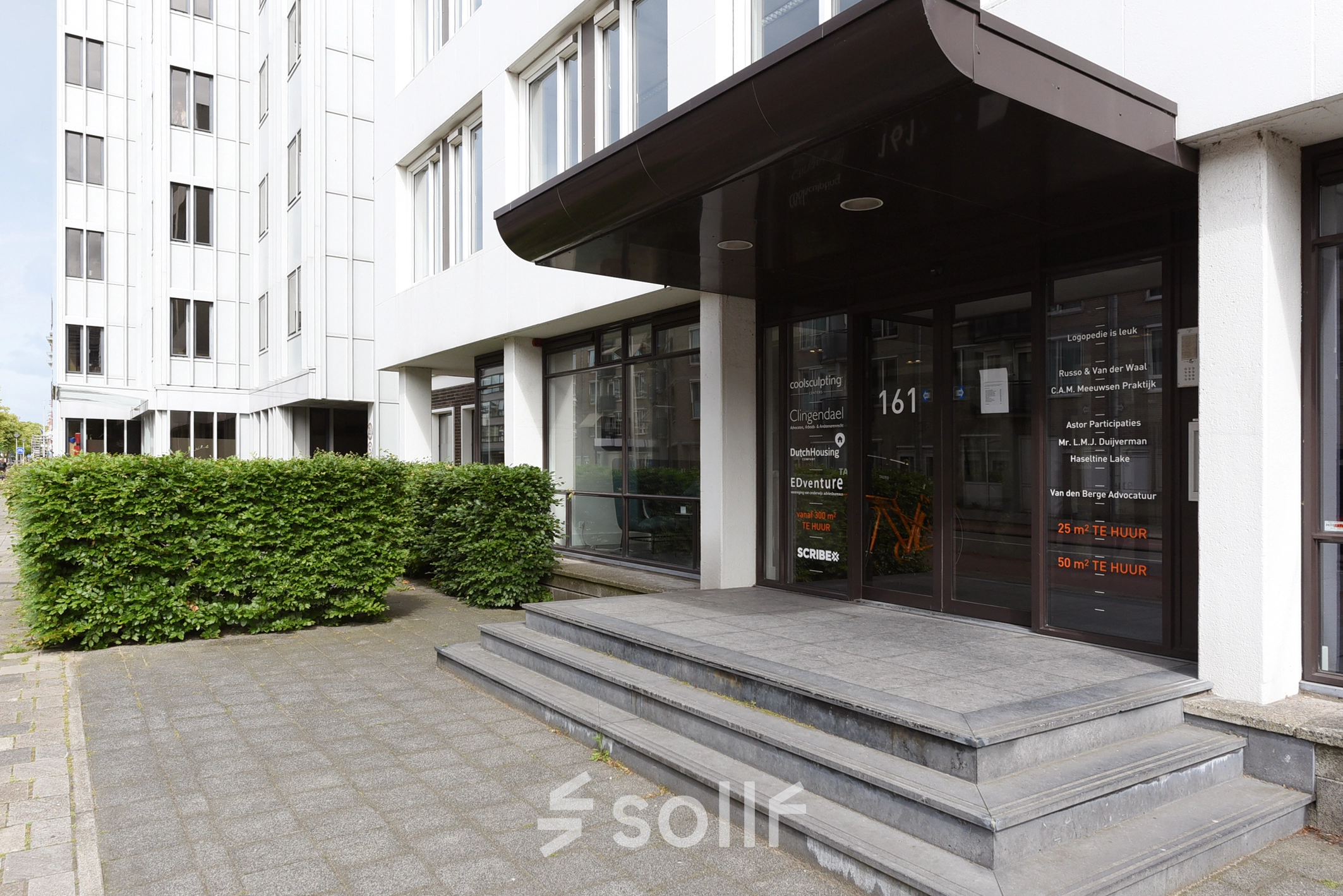 Kantoren aan de Bezuidenhoutseweg 161 in Den Haag Haagse Hout met een moderne entree van een kantoorpand voor verhuur, omgeven door groenvoorzieningen.