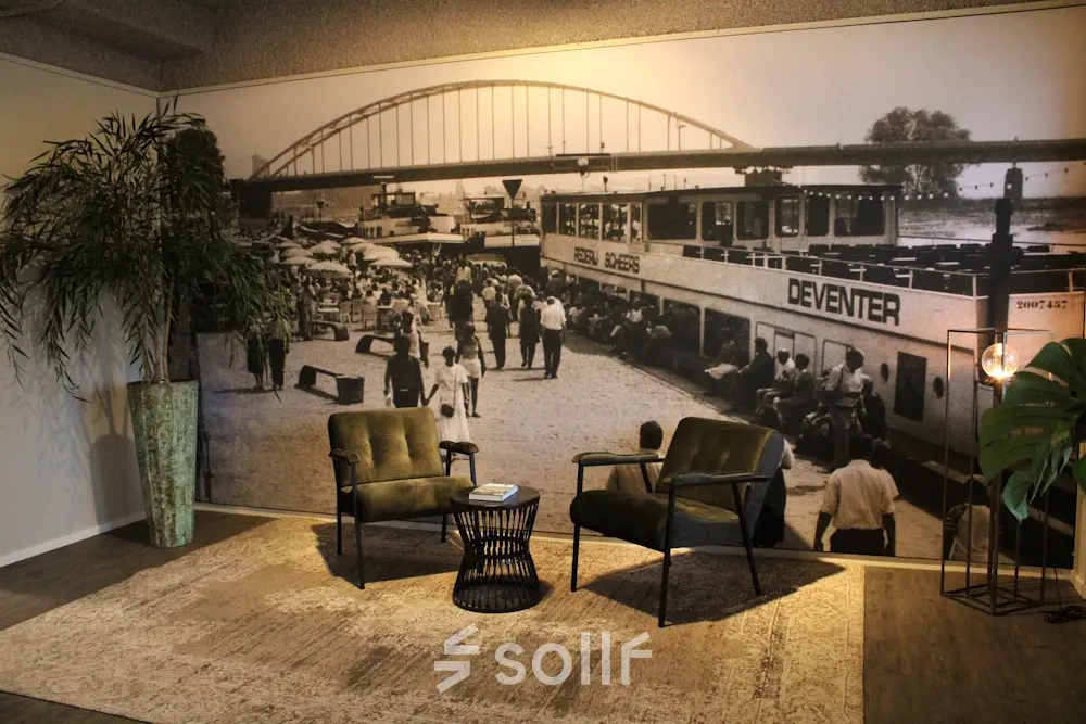 Gezellige loungehoek met historische muurschildering in kantoorpand aan de Keulenstraat 12, Deventer. Geschikt voor kantoorruimte huren.