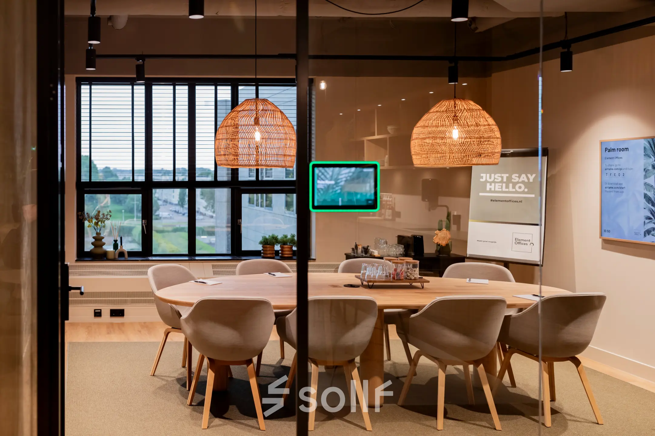 Vergaderruimte in Diemerhof 42, Diemen, met een grote houten tafel omringd door moderne stoelen en hanglampen boven de tafel.