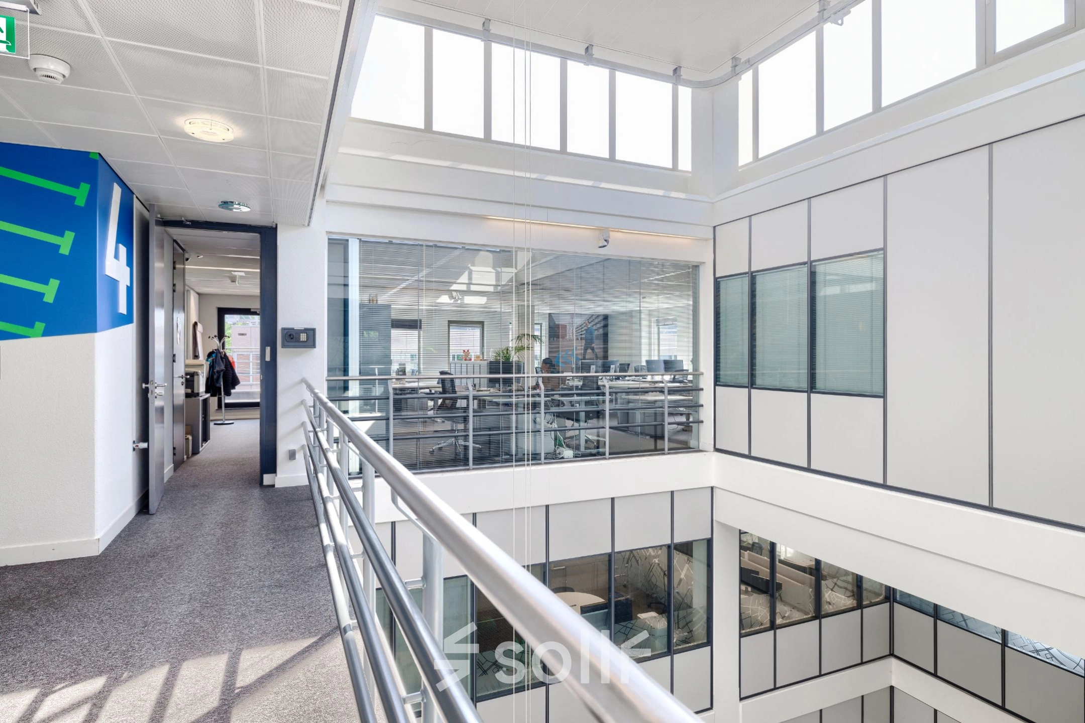 Lichte en moderne kantoorruimte op Wisselwerking 40-48, Diemen, met een open vloerplan en veel ramen. Personen voeren zakelijke gesprekken terwijl ze door het gebouw lopen.