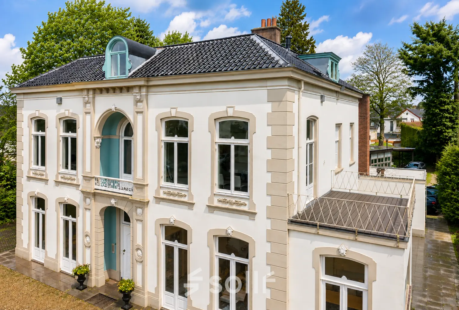 Gevel van een statig kantoorpand aan de Dorpsstraat 77 in Doorn met klassieke details en grote ramen, ideaal voor het huren van een kantoorruimte.