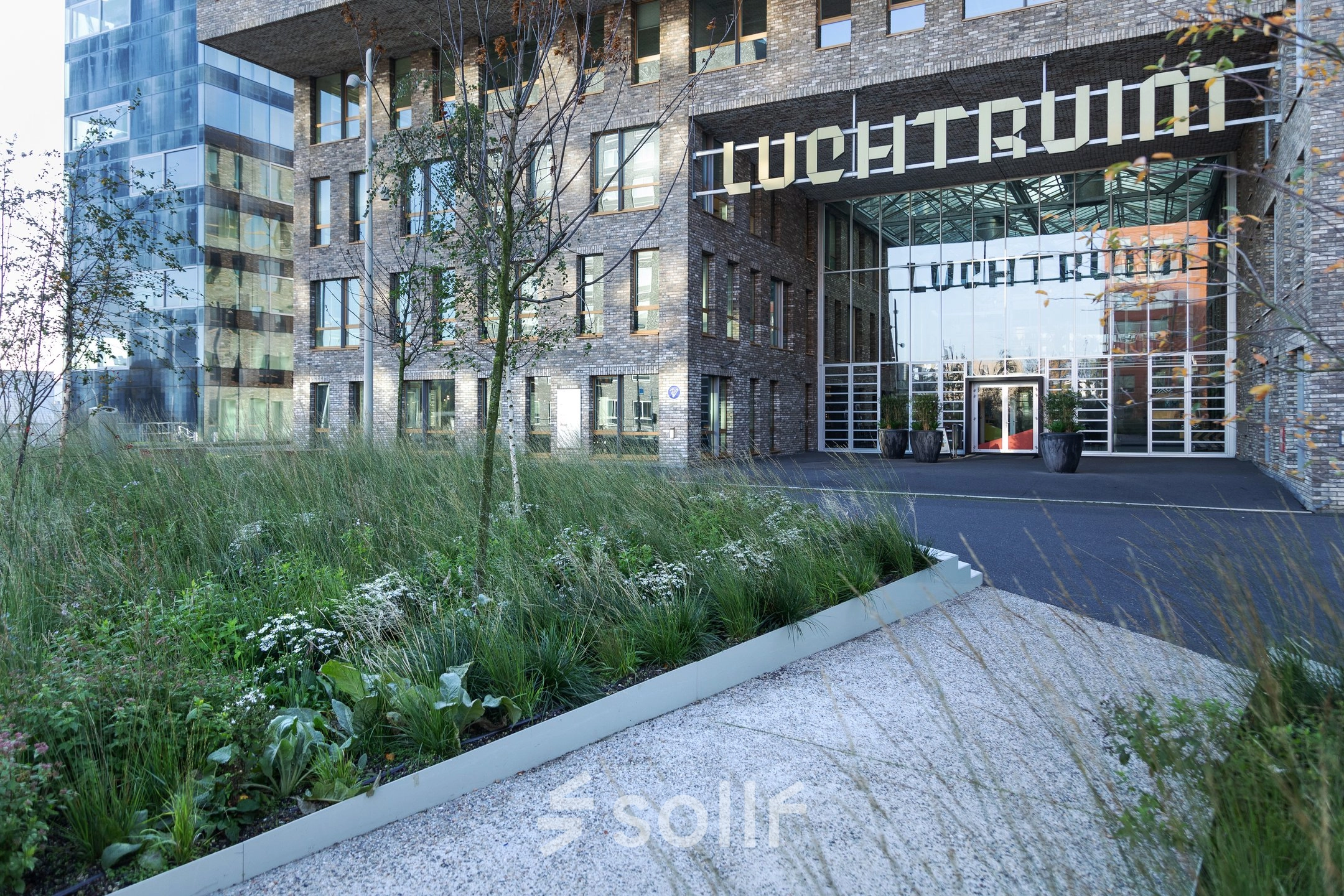 Buitenzicht op het moderne kantoorpand Flight Forum 120-159 in Eindhoven Airport, omringd door groen. Deze locatie biedt diverse mogelijkheden voor kantoorruimte huren.