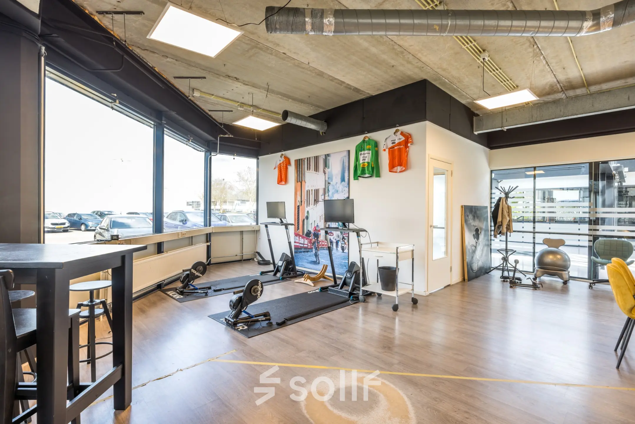 Kantoorruimte te huur op Luchthavenweg 81 bij Eindhoven Airport met moderne inrichting en fitnessapparatuur, ideaal voor een creatieve werkruimte.